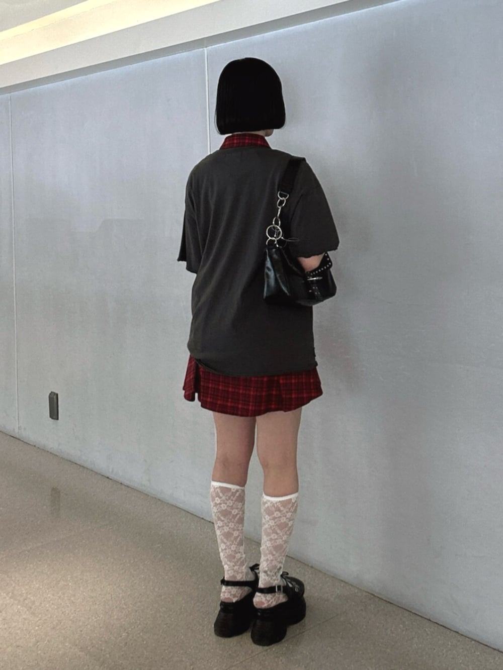 ブラック系のパンプス、ブラック系のハンドバッグ、レッド系のワンピースを着用したレディースの夏コーディネートの3枚目の写真