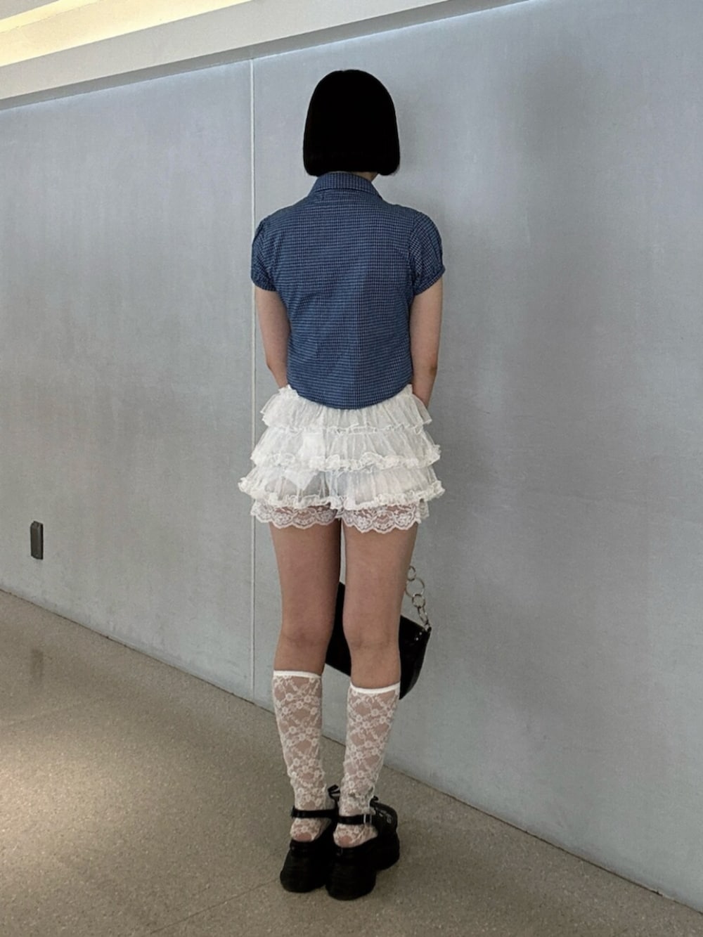 ホワイト系のシャツ/ブラウス、ブラック系のハンドバッグ、ブラック系のパンプスを着用したレディースの夏コーディネートの3枚目の写真