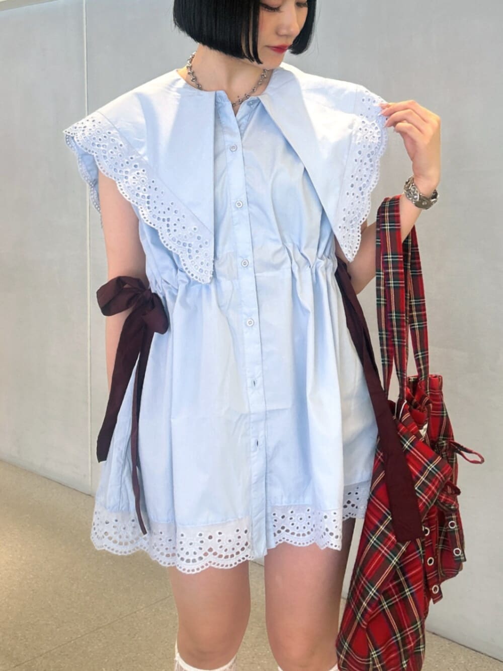 ブルー系のシャツ/ブラウス、レッド系のトートバッグ、レッド系のパンプスを着用したレディースの夏コーディネートの4枚目の写真