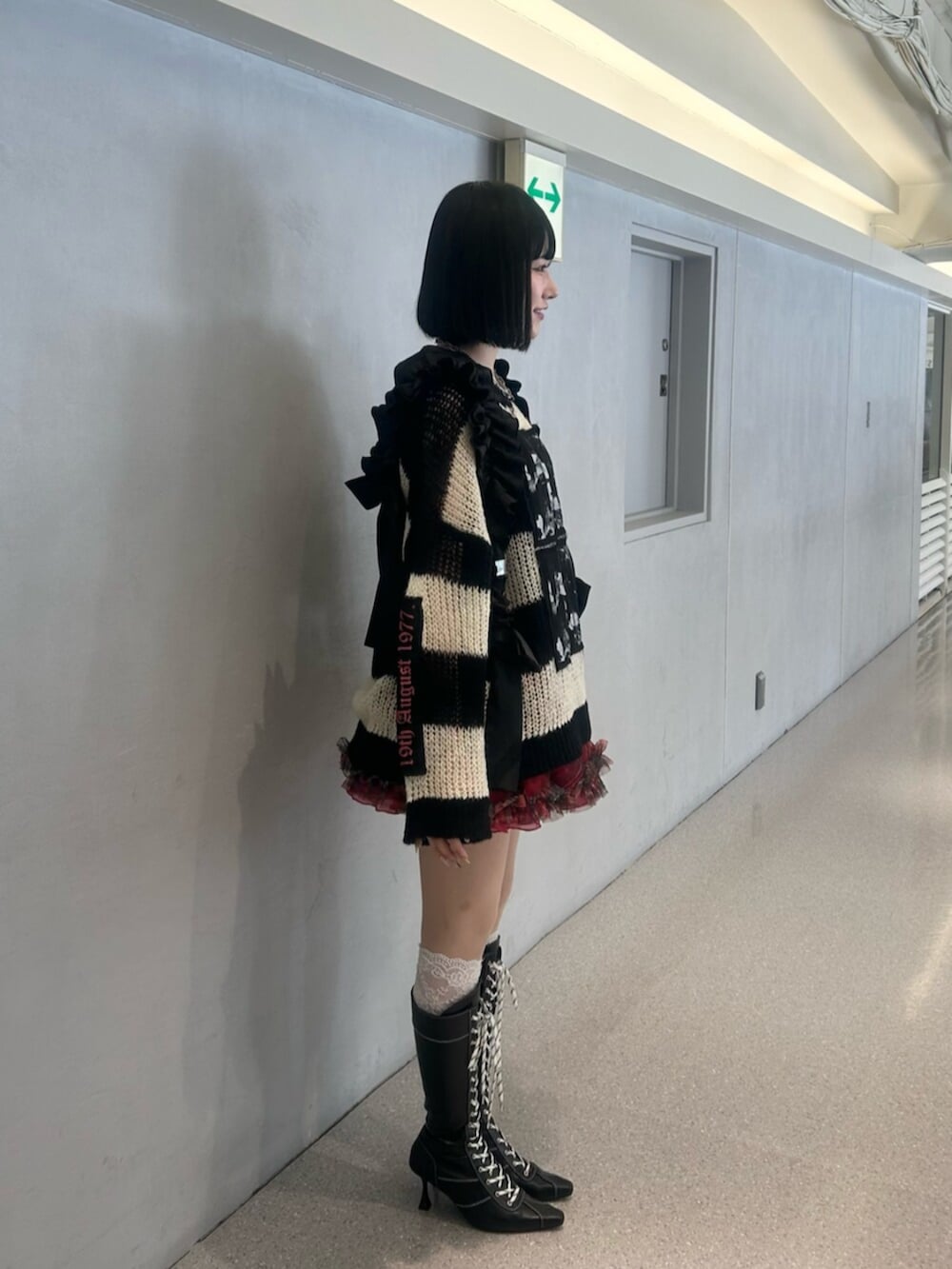 その他のニット/セーター、ブラック系のブーツ、レッド系のスカートを着用したレディースの秋コーディネートの3枚目の写真