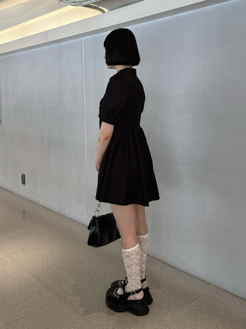 ブラック系のパンプス、ブラック系のワンピース、ブラック系のハンドバッグを着用したレディースの夏コーディネートの2枚目の写真