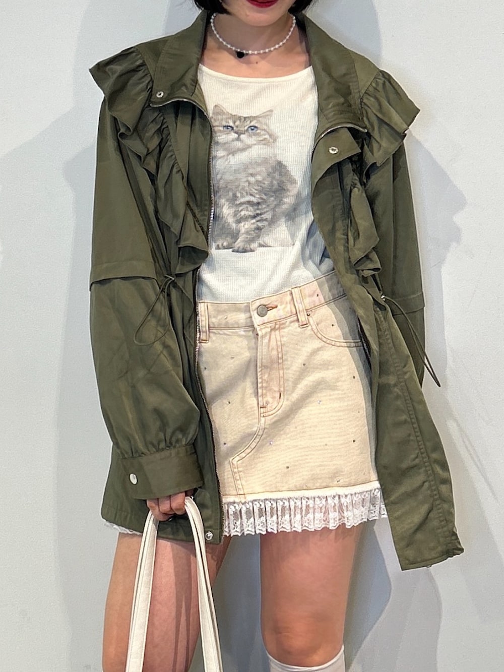 ベージュ系のブルゾン、ホワイト系のTシャツ/カットソー、ベージュ系のデニムスカートを着用したレディースの秋コーディネートの5枚目の写真
