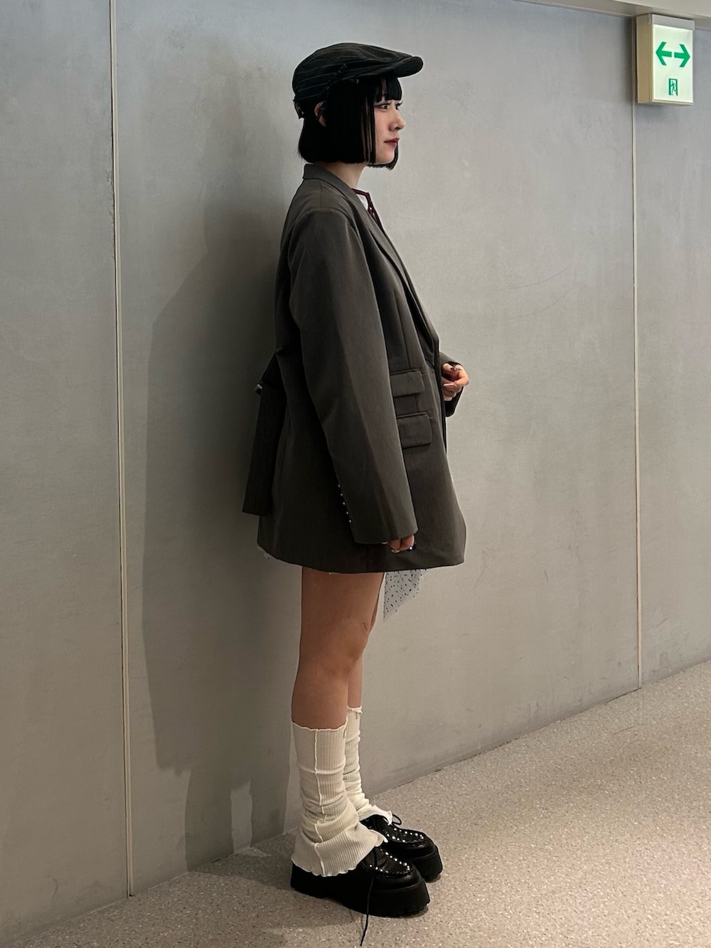 グレー系のテーラードジャケット、ブルー系のワンピース、ブラック系のローファーを着用したレディースの冬コーディネートの3枚目の写真