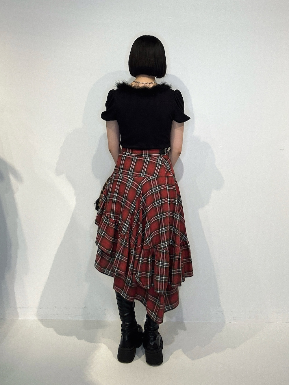 レッド系のスカート、ブラック系のブーツ、ブラウン系のハンドバッグを着用したレディースの夏コーディネートの3枚目の写真