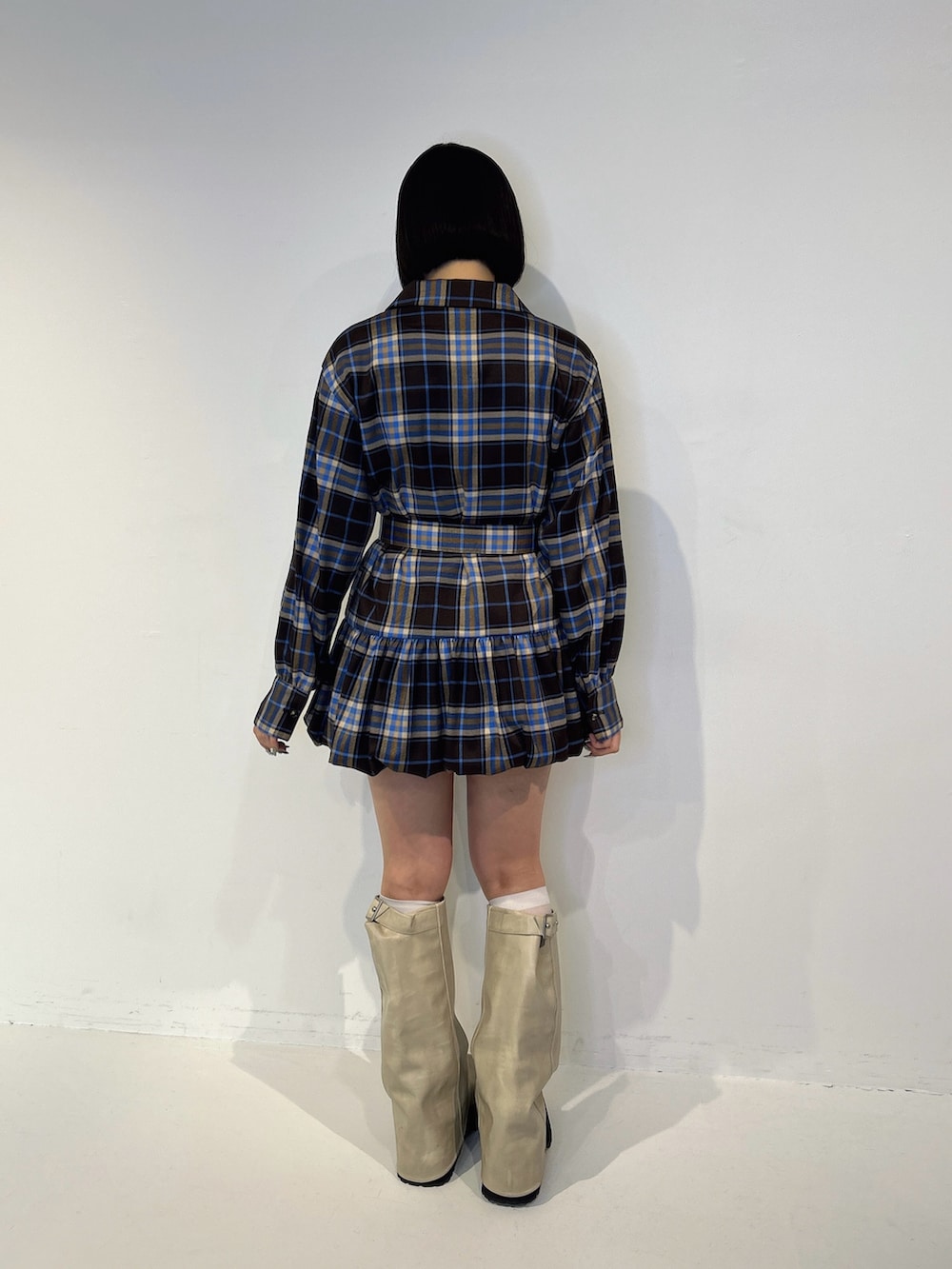 ブラウン系のワンピース、ホワイト系のブーツ、ホワイト系のTシャツ/カットソーを着用したレディースの秋コーディネートの3枚目の写真