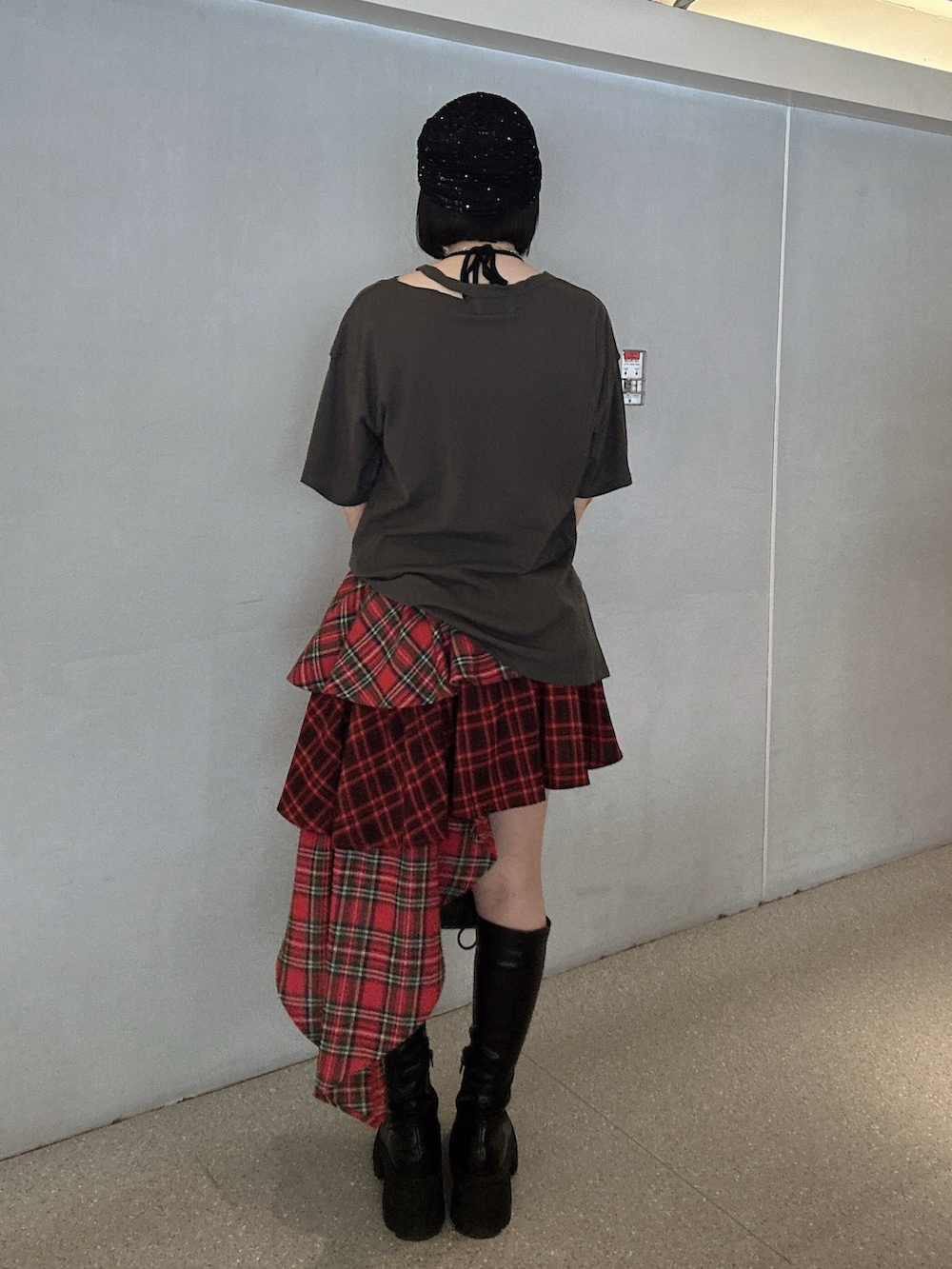 ブラック系のTシャツ/カットソー、レッド系のスカート、ブラック系のブーツを着用したレディースの春コーディネートの3枚目の写真