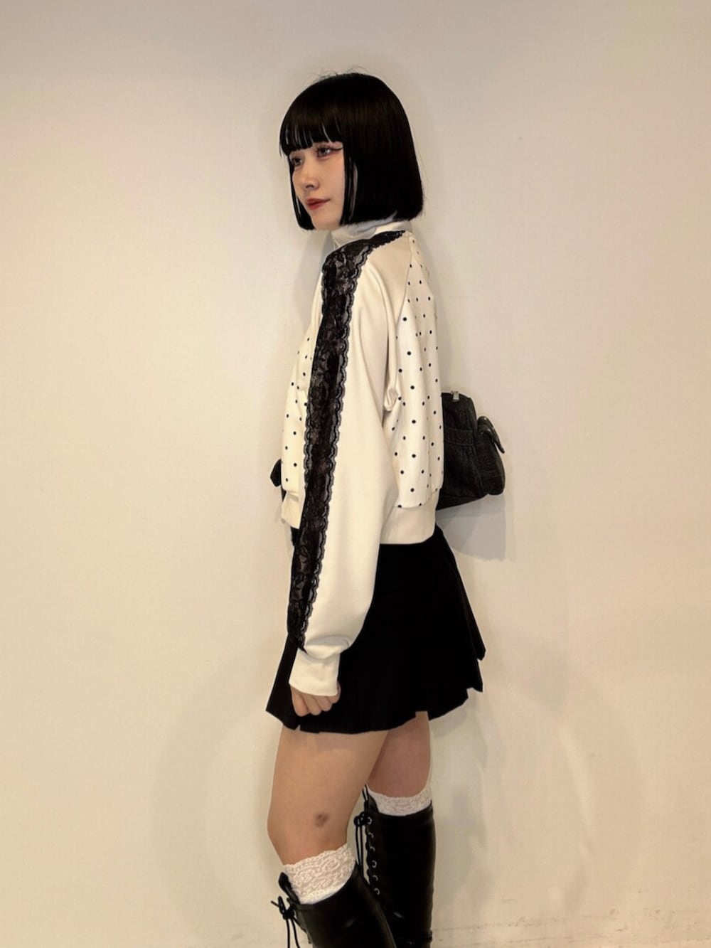 ブラック系のボストンバッグ、ブラック系のブーツ、ホワイト系のTシャツ/カットソーを着用したレディースの夏コーディネートの7枚目の写真
