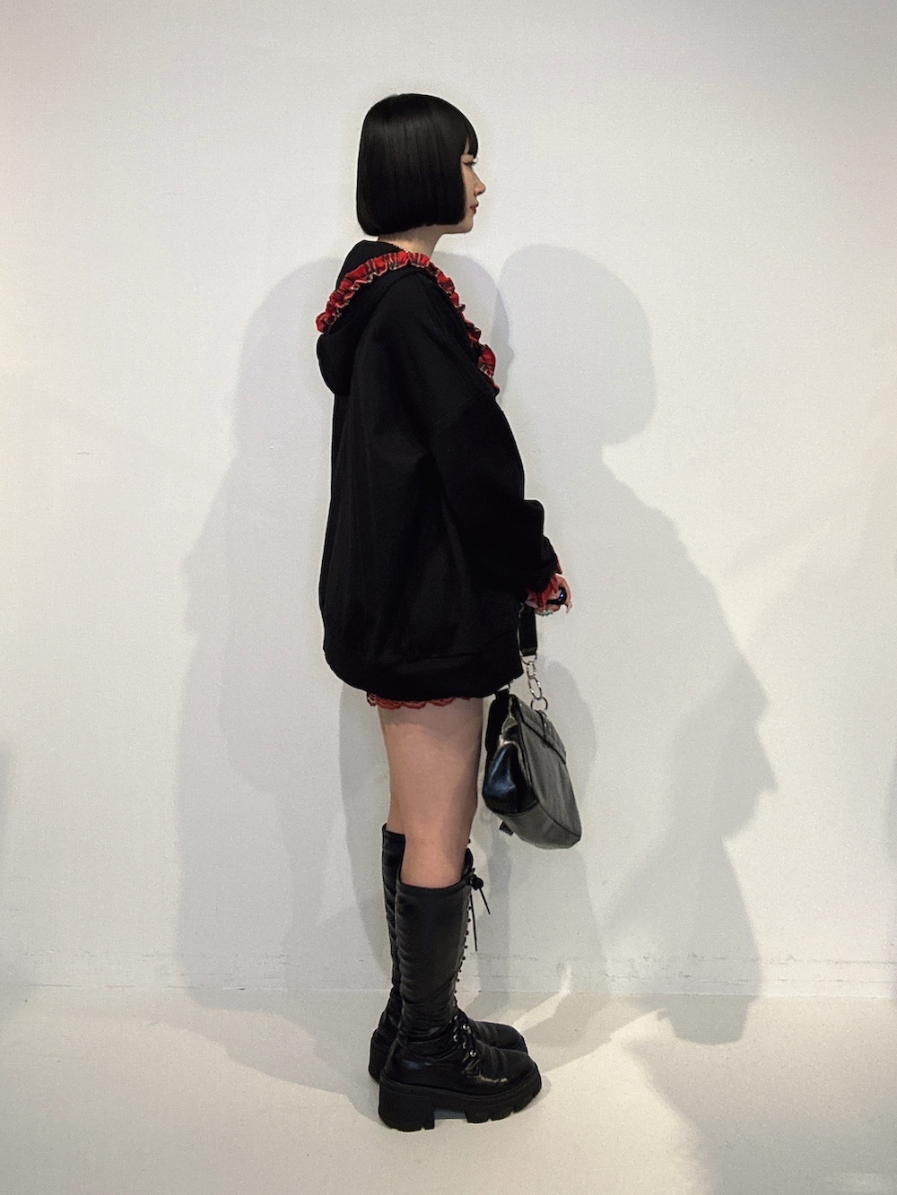 ブラック系のその他トップス、レッド系のその他パンツ、ブラック系のブーツを着用したレディースの夏コーディネートの2枚目の写真