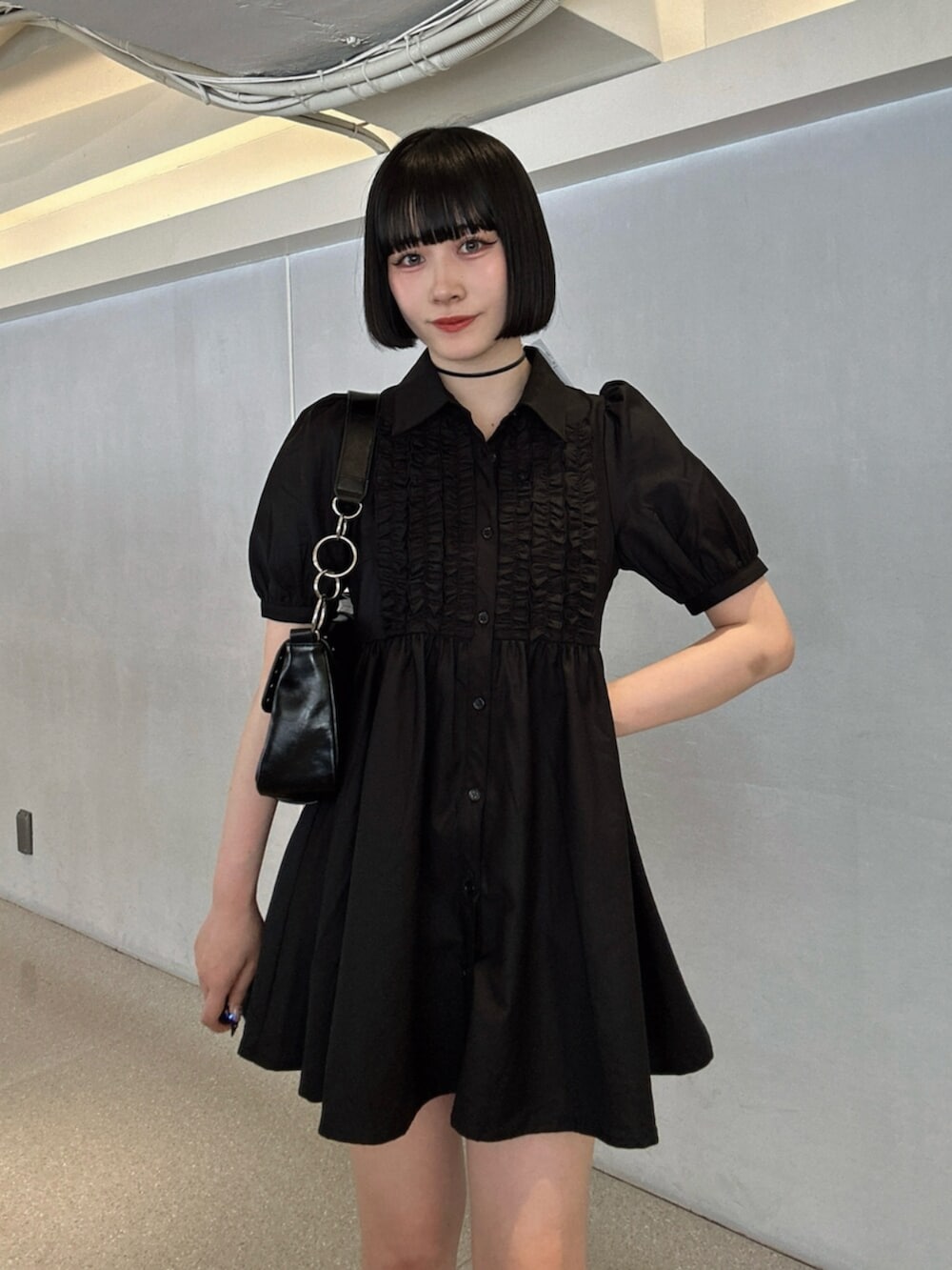 ブラック系のパンプス、ブラック系のワンピース、ブラック系のハンドバッグを着用したレディースの夏コーディネートの4枚目の写真