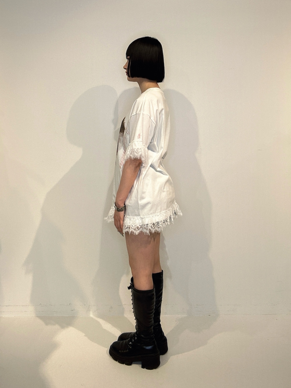 ホワイト系のTシャツ/カットソー、ブラック系のブーツ、シルバー系のネックレスを着用したレディースの夏コーディネートの2枚目の写真