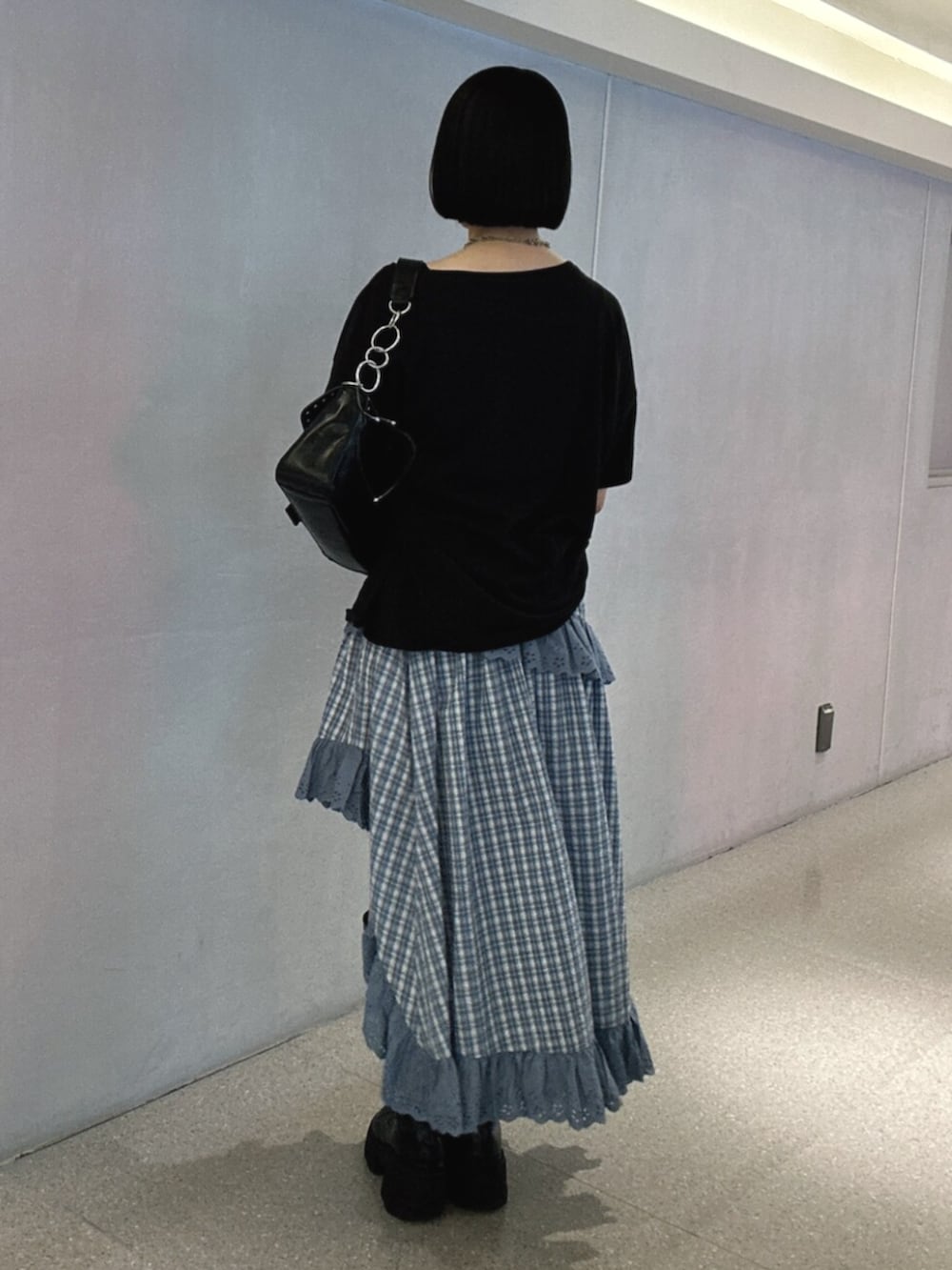 ブラック系のブーツ、ブルー系のスカート、ブラック系のTシャツ/カットソーを着用したレディースの夏コーディネートの3枚目の写真