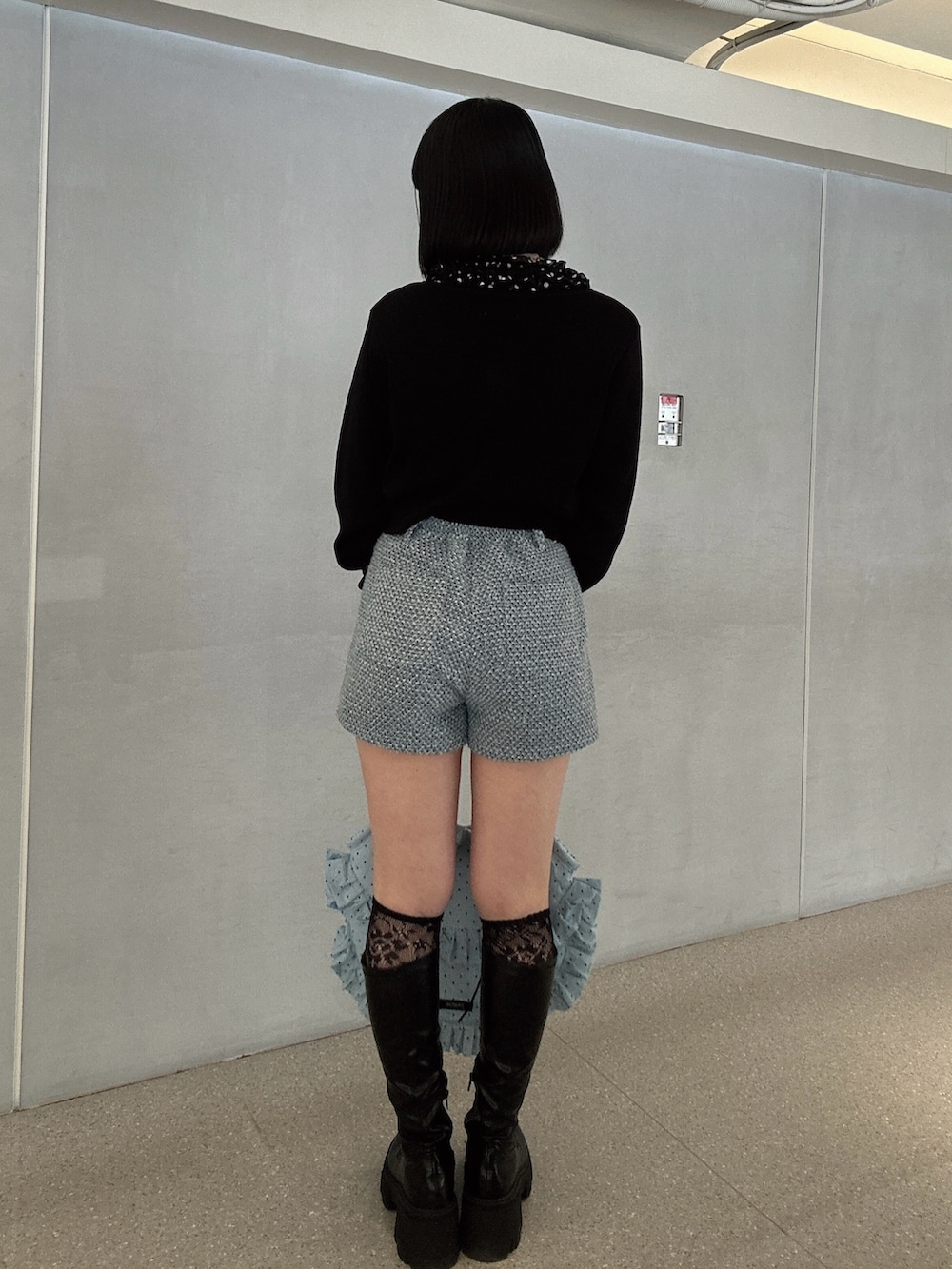 ブラック系のニット/セーター、ブラック系のシャツ/ブラウス、ブルー系のその他パンツを着用したレディースの春コーディネートの2枚目の写真