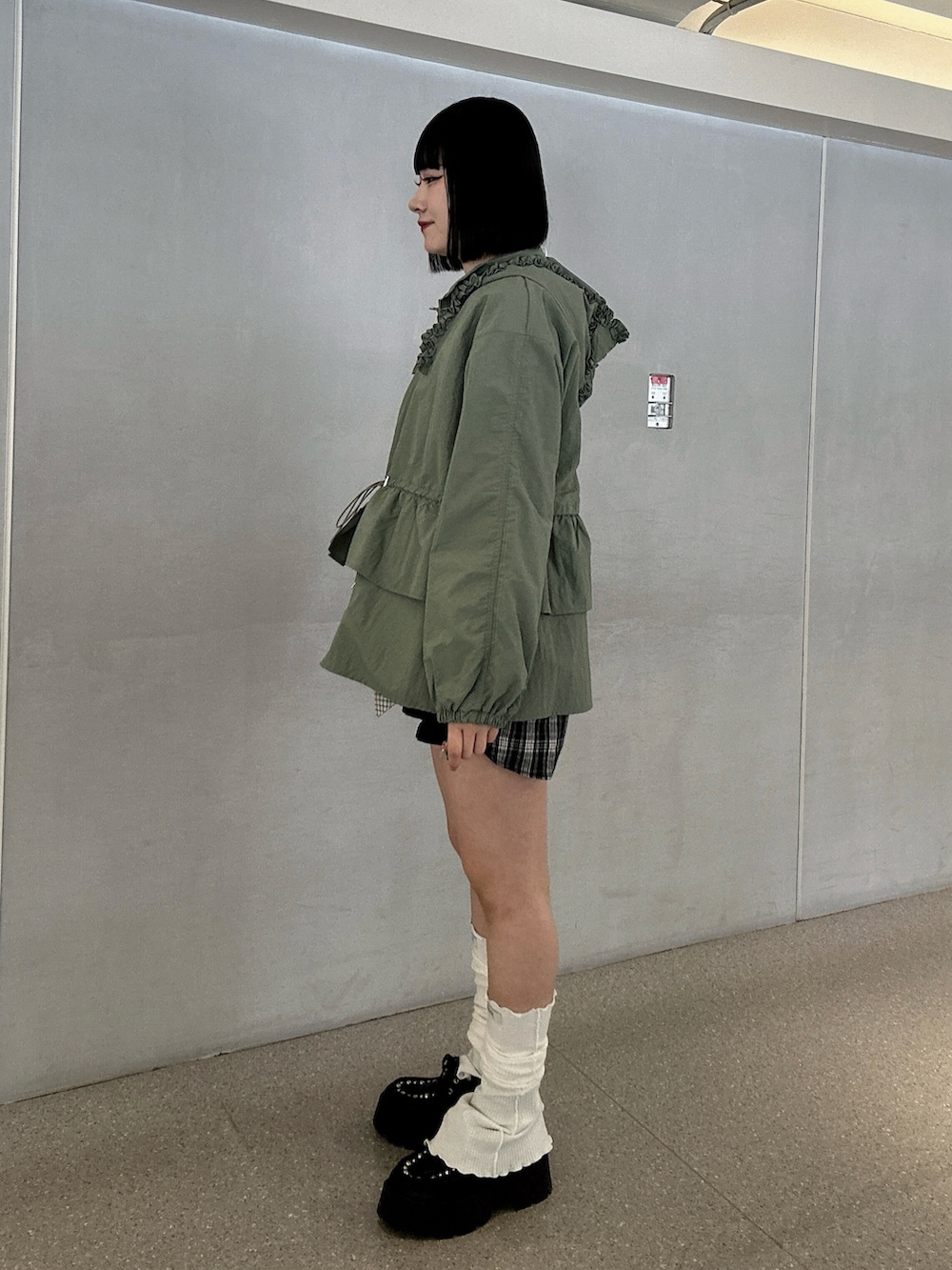 グリーン系のナイロンジャケット、ブラック系のローファー、ブラック系のその他パンツを着用したレディースの春コーディネートの2枚目の写真