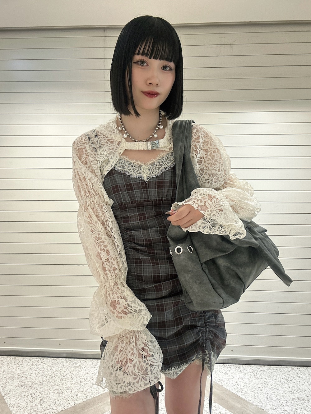 ホワイト系のカーディガン/ボレロ、ブラウン系のワンピース、グレー系のトートバッグを着用したレディースの春コーディネートの5枚目の写真