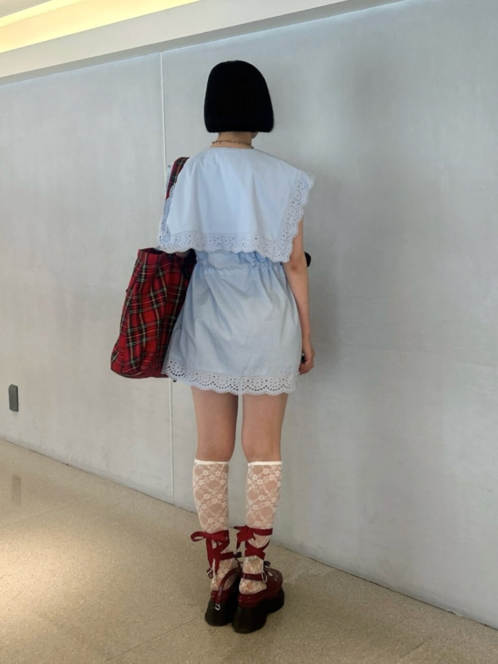 ブルー系のシャツ/ブラウス、レッド系のトートバッグ、レッド系のパンプスを着用したレディースの夏コーディネートの3枚目の写真
