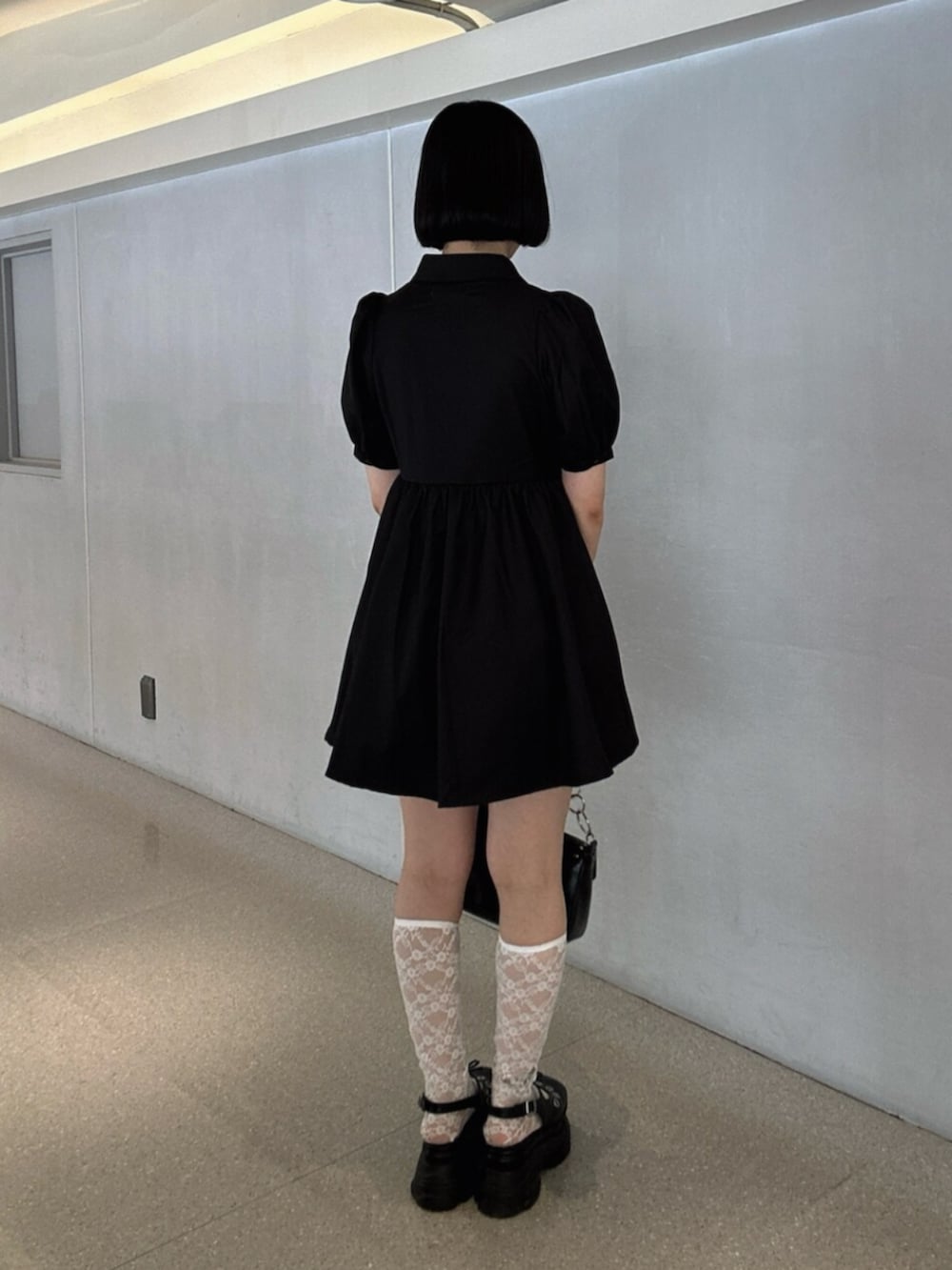 ブラック系のパンプス、ブラック系のワンピース、ブラック系のハンドバッグを着用したレディースの夏コーディネートの3枚目の写真
