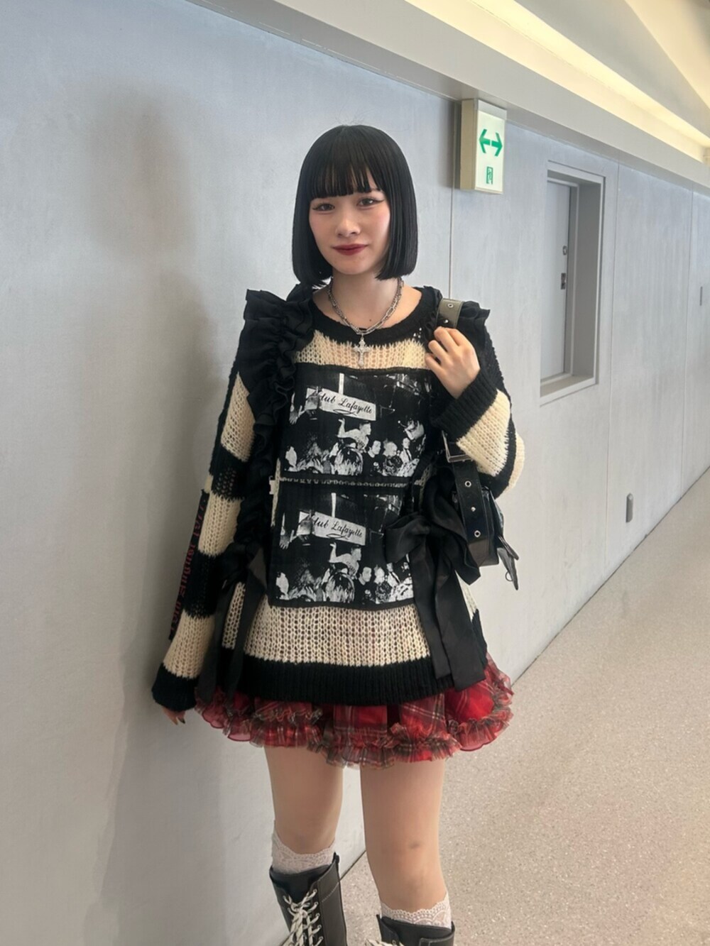 その他のニット/セーター、ブラック系のブーツ、レッド系のスカートを着用したレディースの秋コーディネートの2枚目の写真