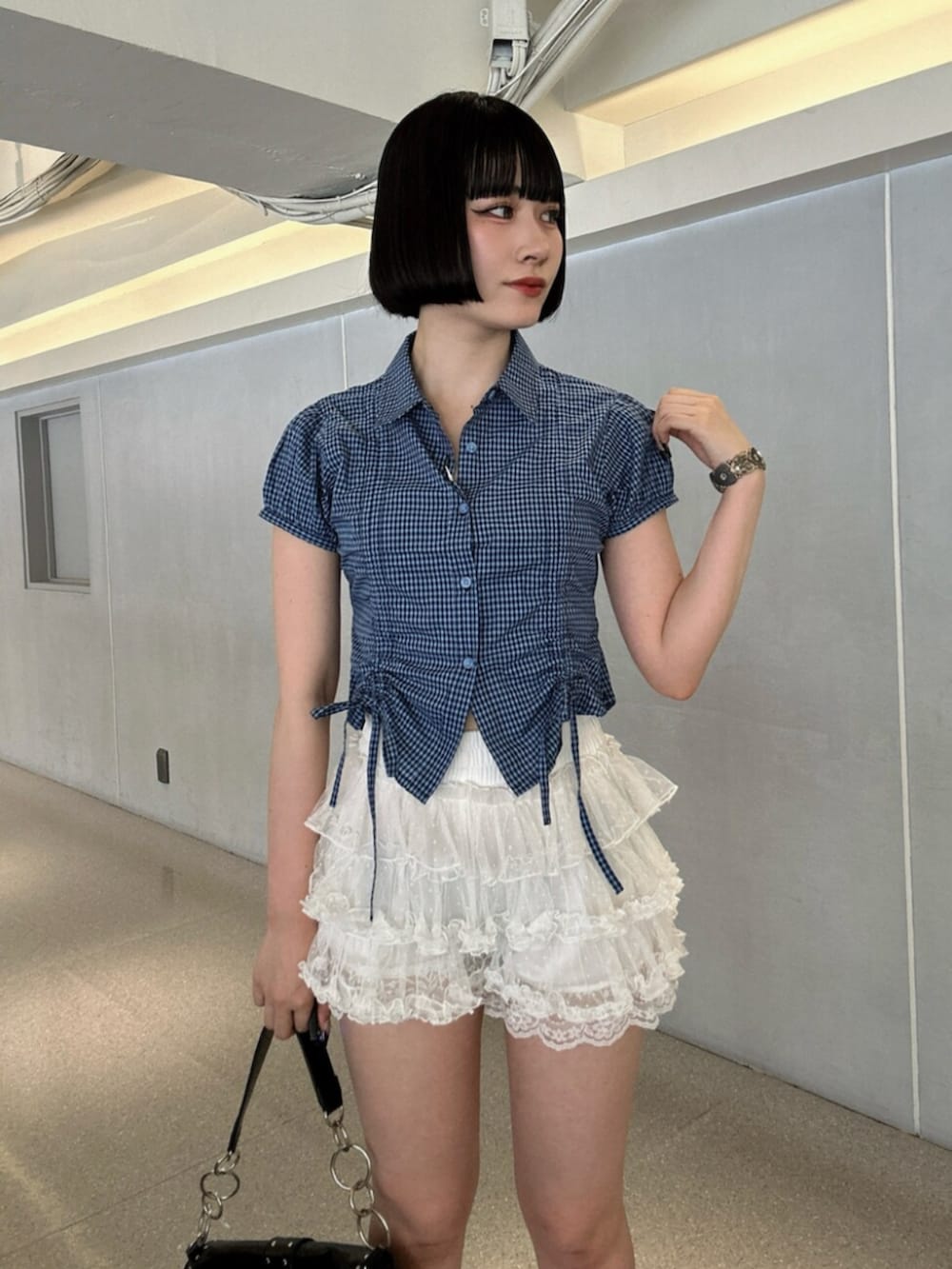 ホワイト系のシャツ/ブラウス、ブラック系のハンドバッグ、ブラック系のパンプスを着用したレディースの夏コーディネートの4枚目の写真