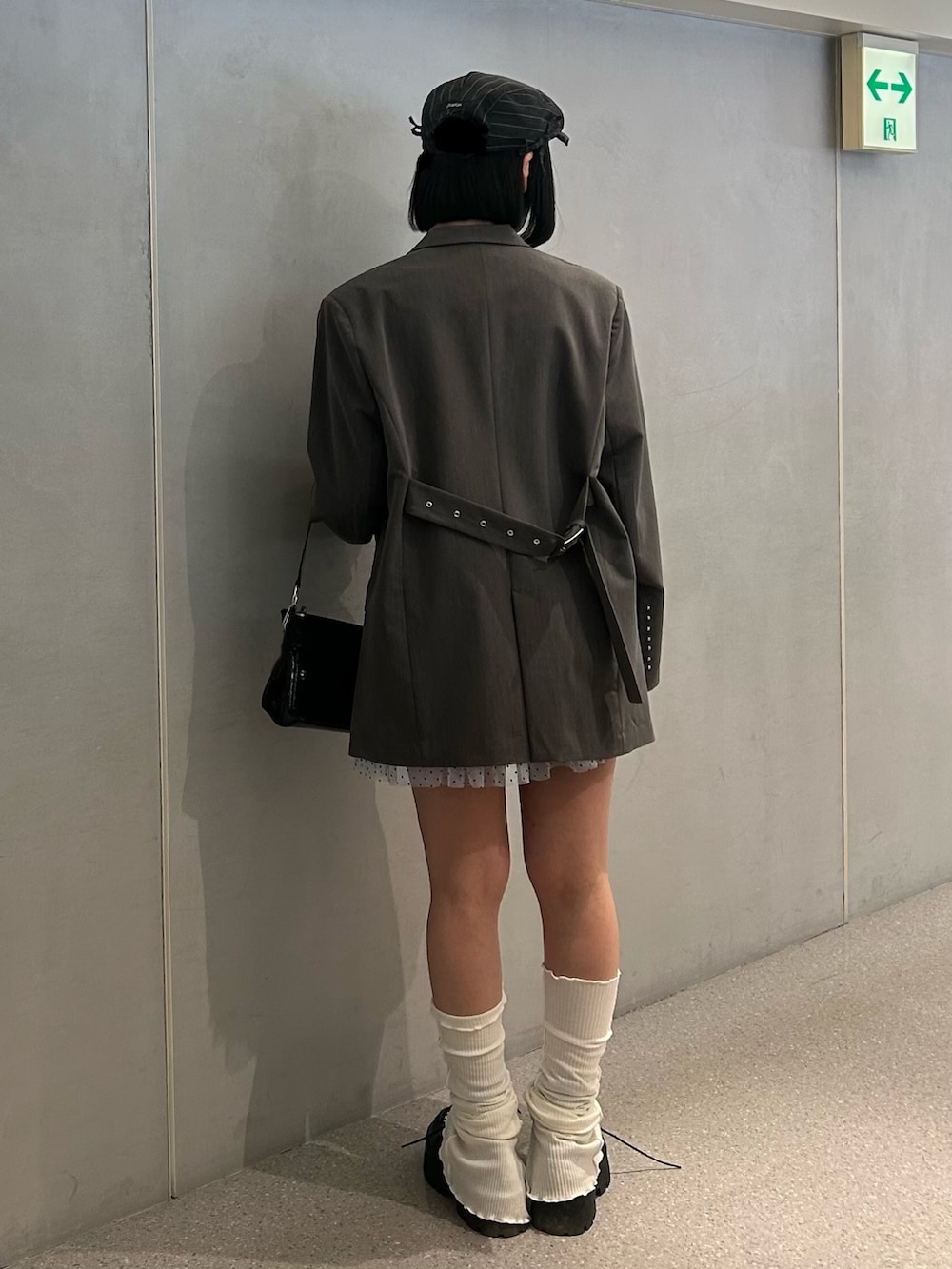 グレー系のテーラードジャケット、ブルー系のワンピース、ブラック系のローファーを着用したレディースの冬コーディネートの2枚目の写真