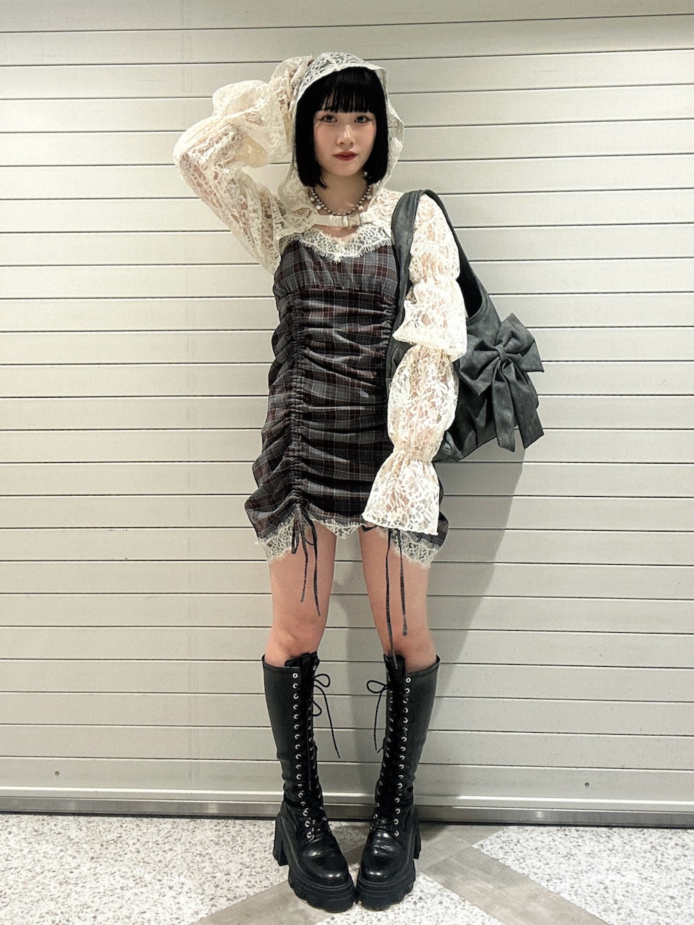 ホワイト系のカーディガン/ボレロ、ブラウン系のワンピース、グレー系のトートバッグを着用したレディースの春コーディネートの4枚目の写真