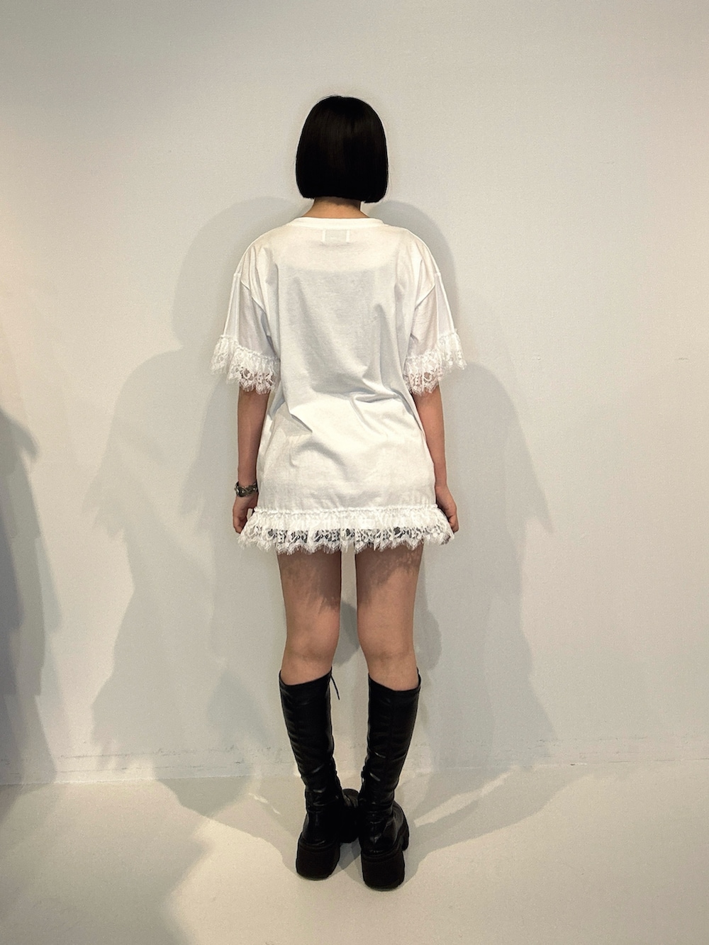 ホワイト系のTシャツ/カットソー、ブラック系のブーツ、シルバー系のネックレスを着用したレディースの夏コーディネートの3枚目の写真