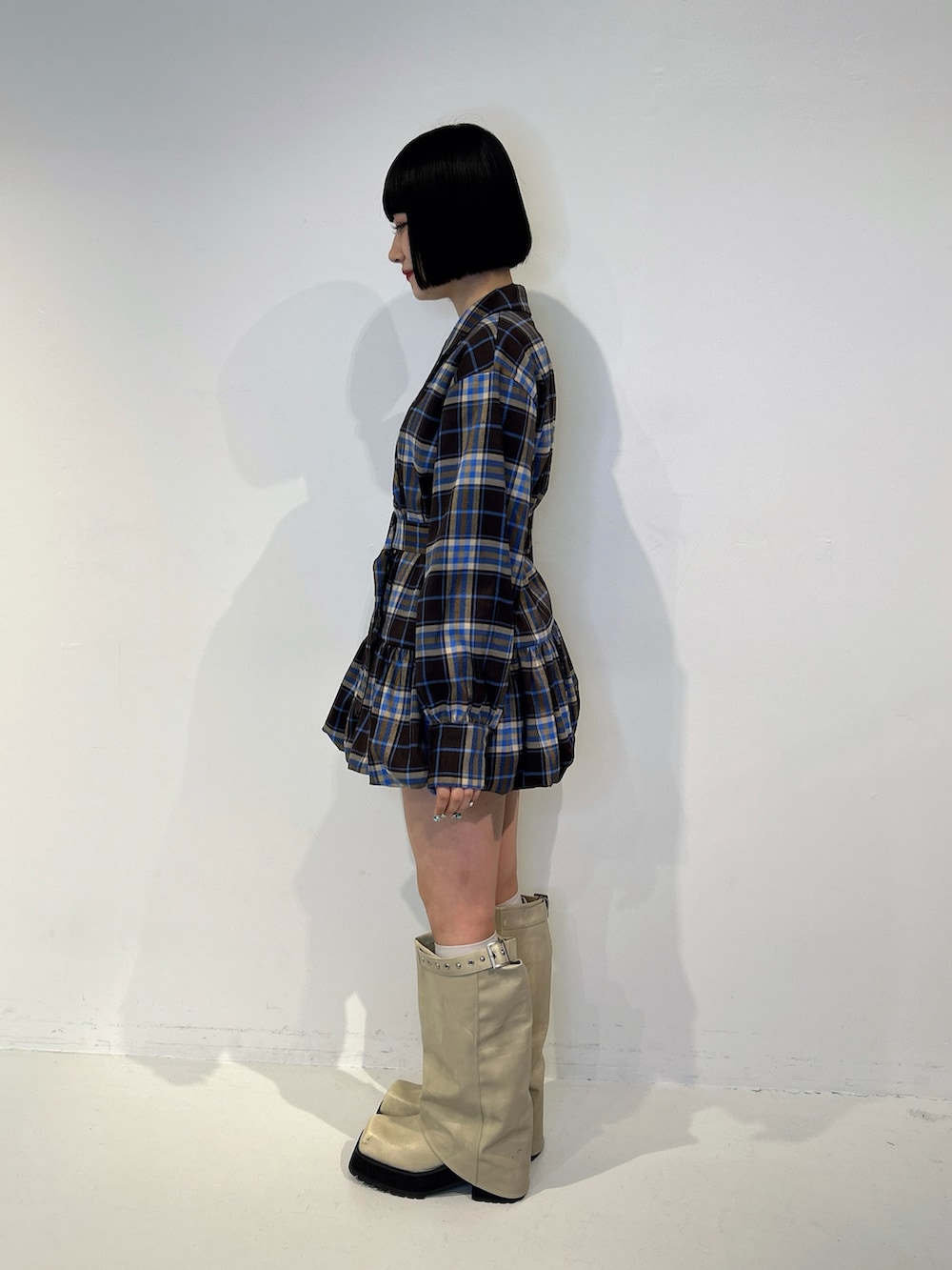 ブラウン系のワンピース、ホワイト系のブーツ、ホワイト系のTシャツ/カットソーを着用したレディースの秋コーディネートの2枚目の写真