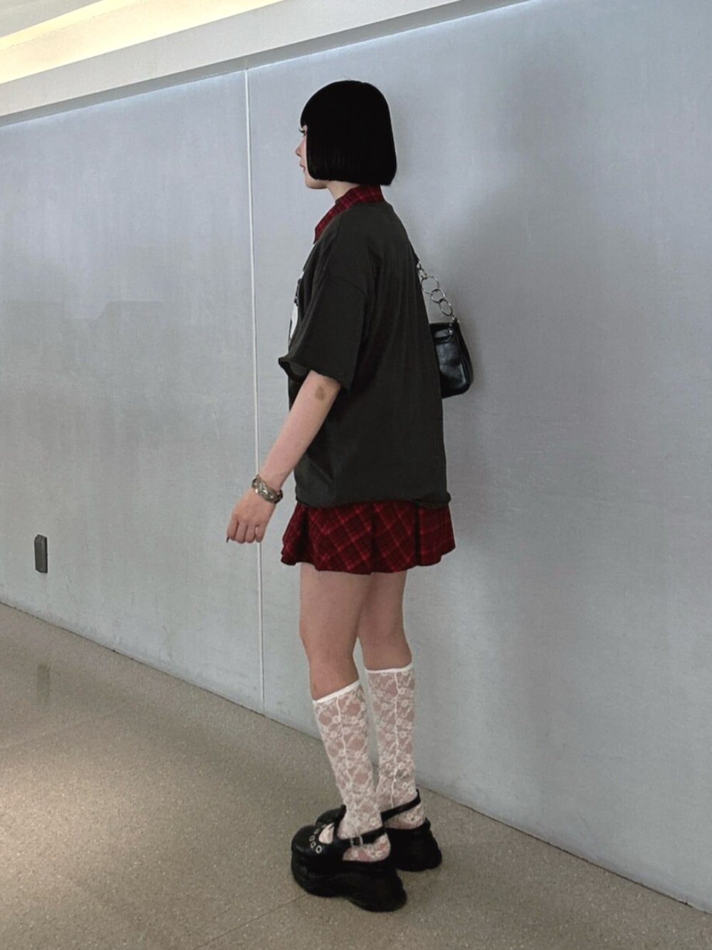 ブラック系のパンプス、ブラック系のハンドバッグ、レッド系のワンピースを着用したレディースの夏コーディネートの2枚目の写真