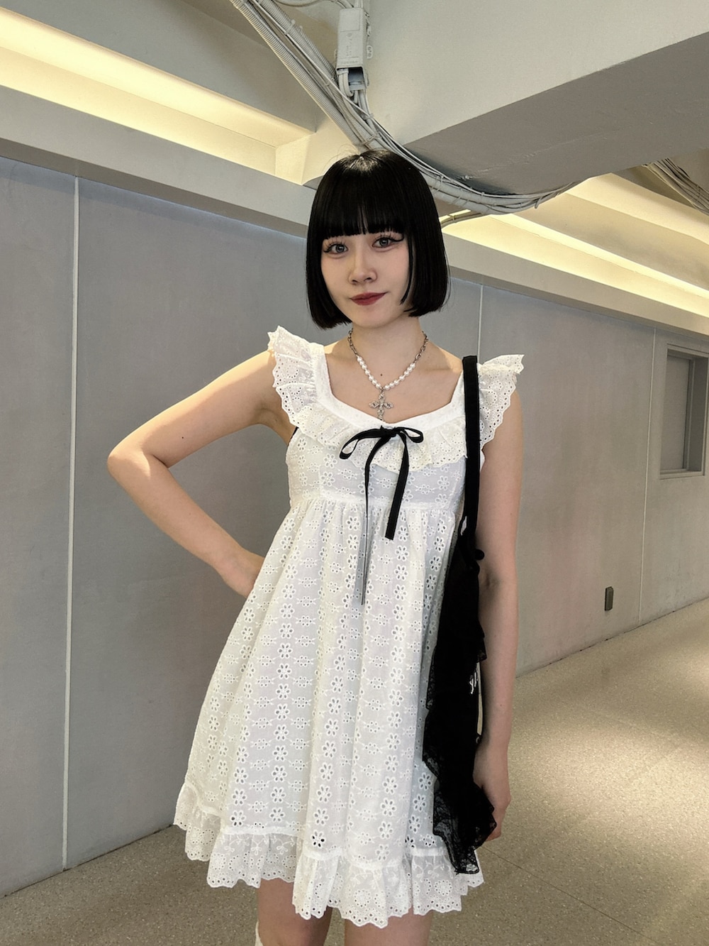 ホワイト系のワンピース、ブラック系のブーツを着用したレディースの春コーディネートの4枚目の写真