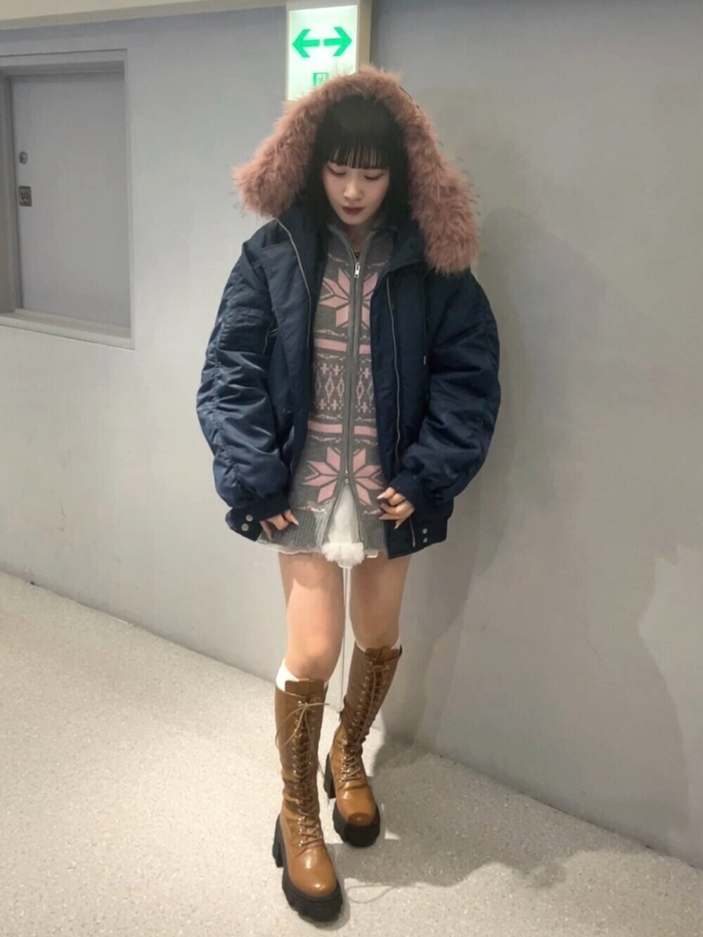 ブラウン系のブーツ、ブルー系のブルゾン、グレー系のカーディガン/ボレロを着用したレディースの秋コーディネートの2枚目の写真