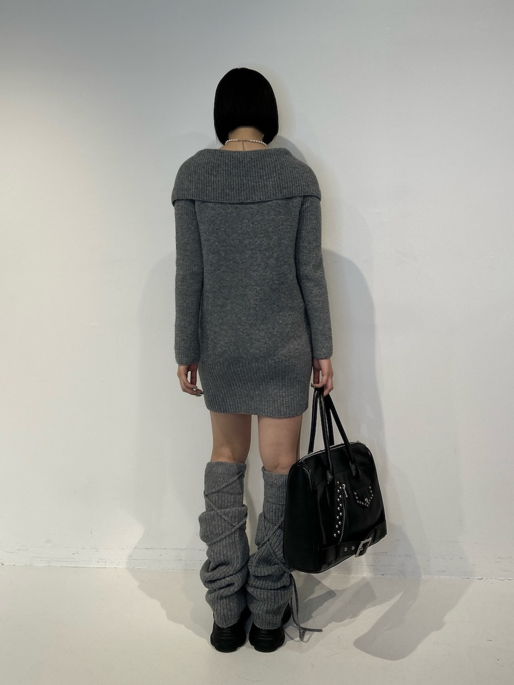 グレー系のワンピース、ブラック系のハンドバッグ、ブラック系のサンダルを着用したレディースの秋コーディネートの3枚目の写真