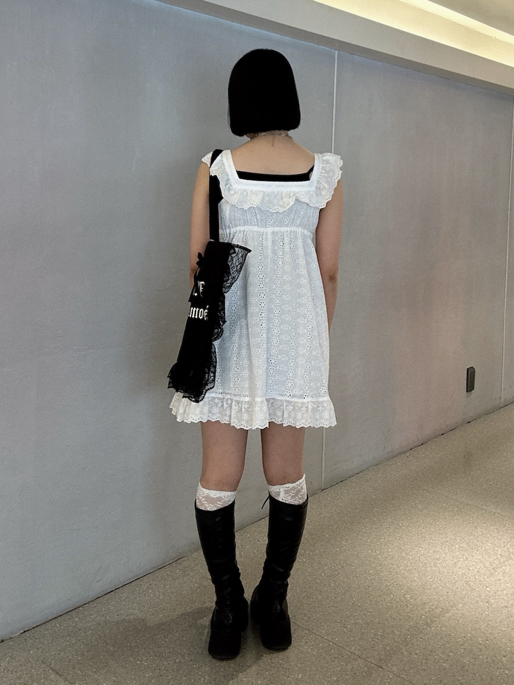 ホワイト系のワンピース、ブラック系のブーツを着用したレディースの春コーディネートの3枚目の写真