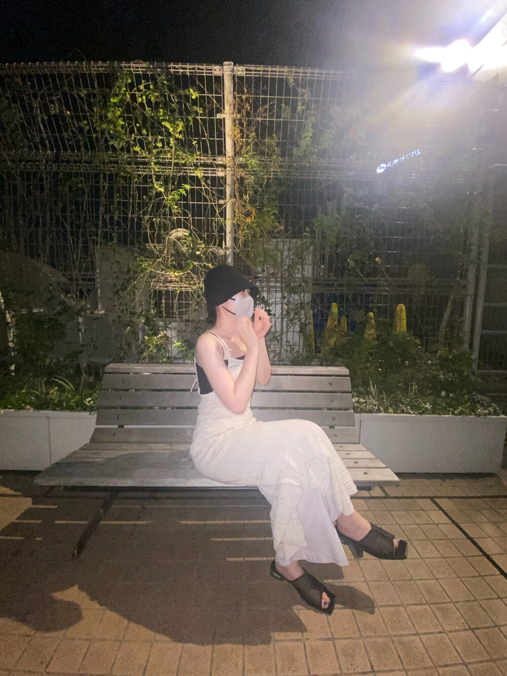 ホワイト系のワンピース、ホワイト系のスラックス、ブラック系のサンダルを着用したレディースの冬コーディネートの2枚目の写真