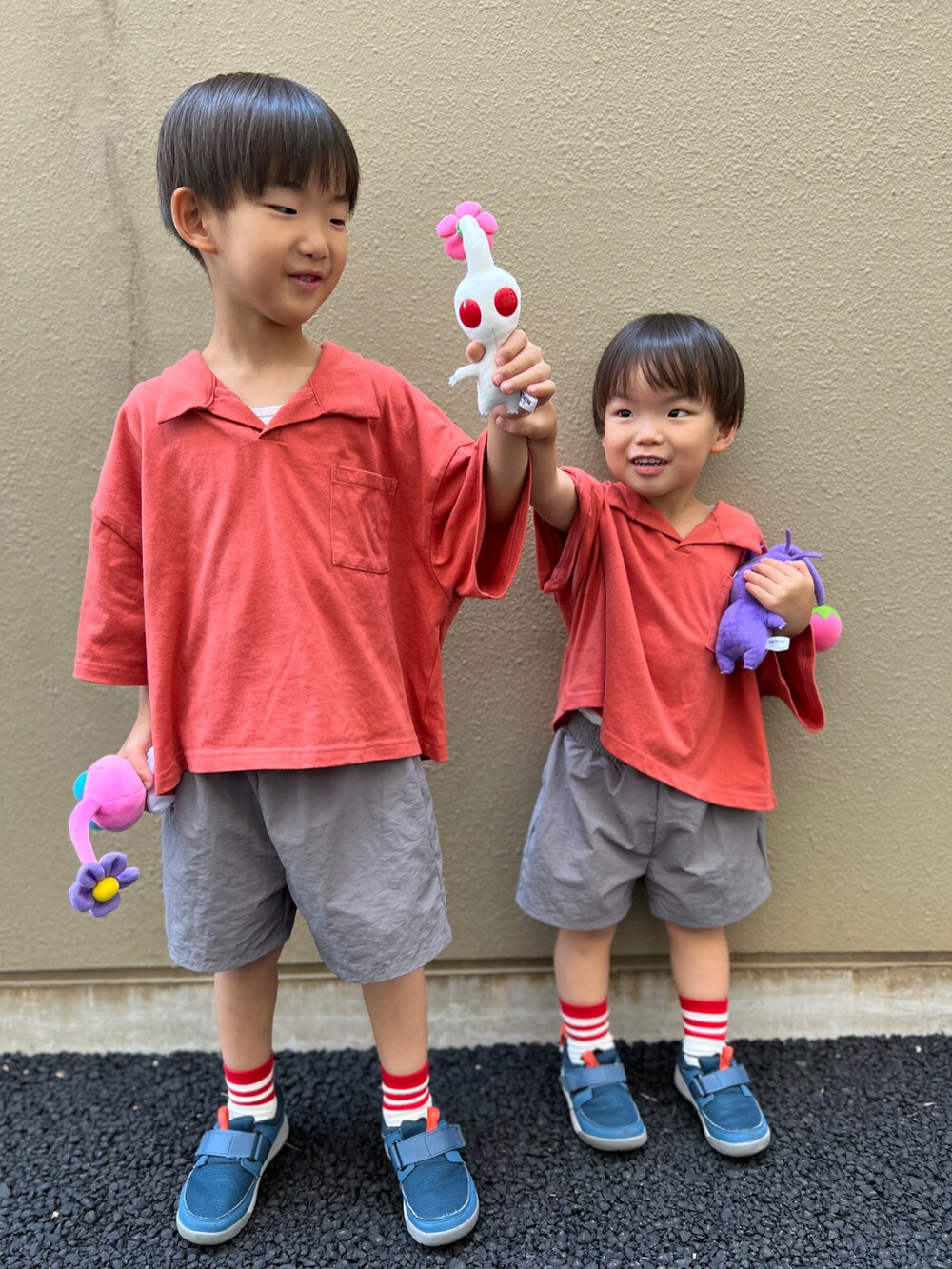 レッド系のセットアップ、ブルー系のスニーカー、ホワイト系のソックス/靴下を着用したキッズの夏コーディネートの2枚目の写真