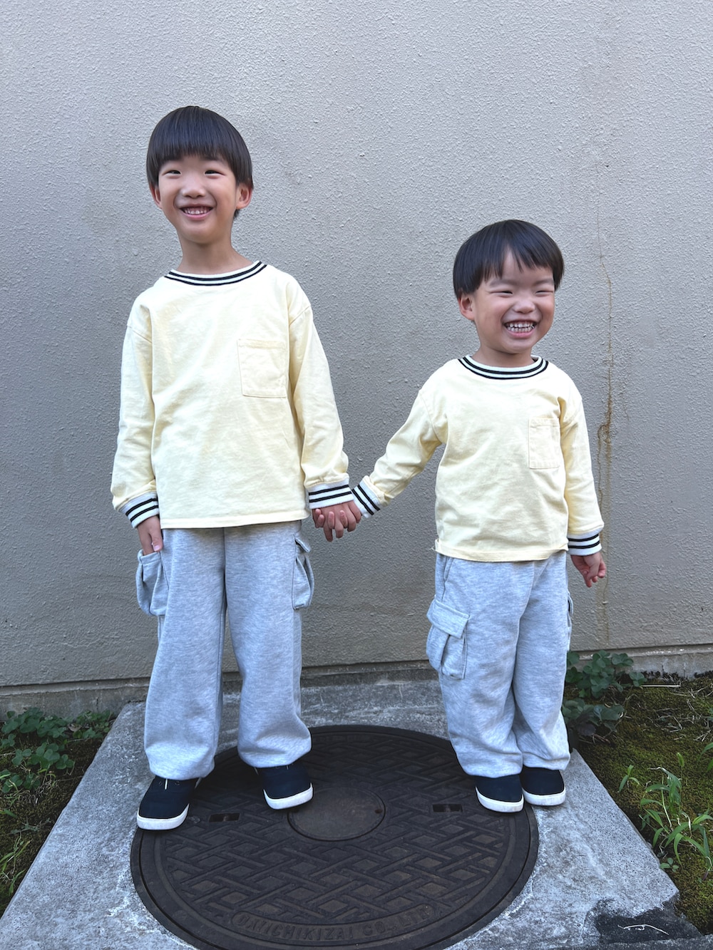 イエロー系のTシャツ/カットソー、グレー系のカーゴパンツ、ブラック系のスニーカーを着用したキッズの秋コーディネートの2枚目の写真