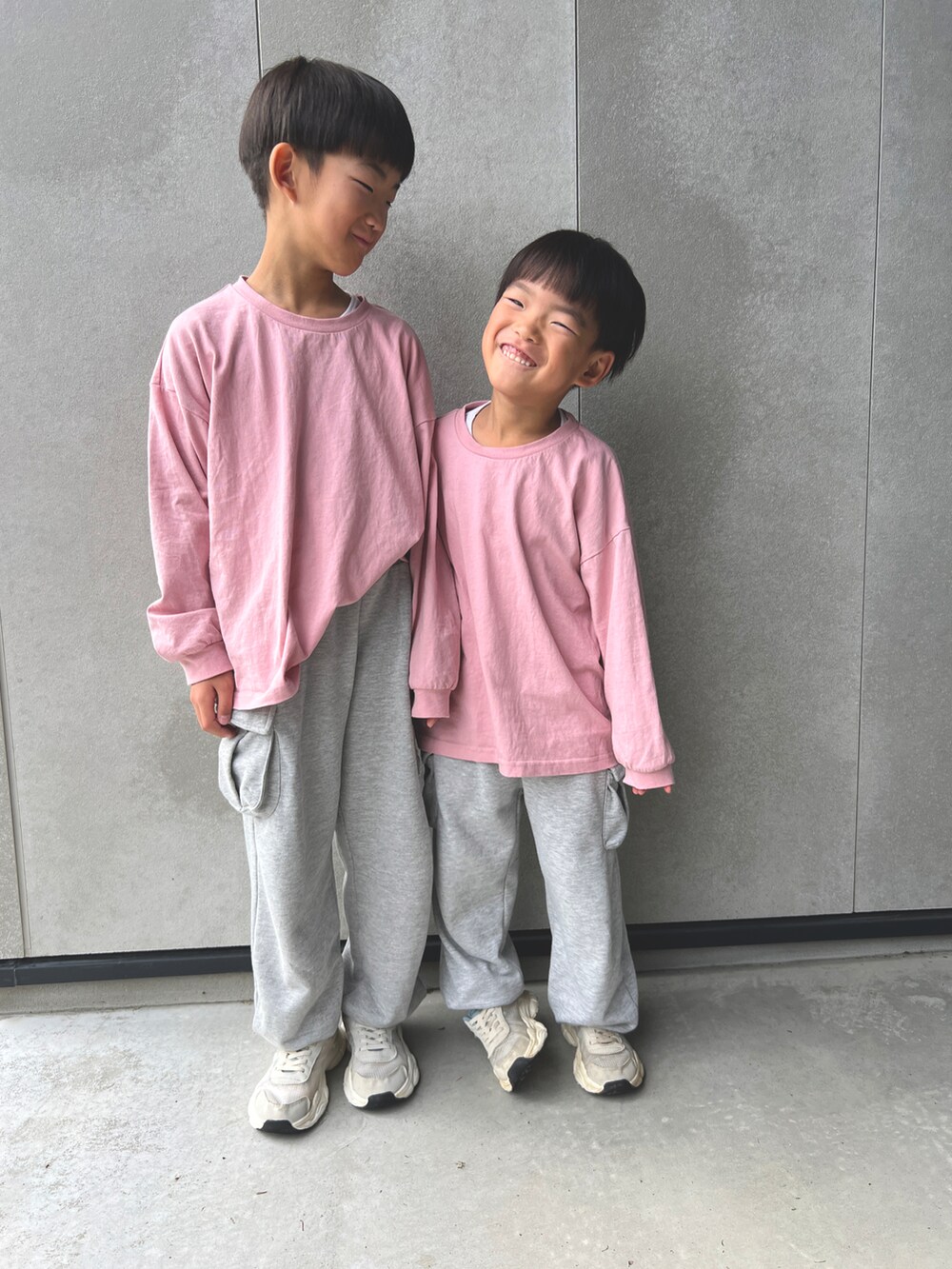 ピンク系のTシャツ/カットソー、グレー系のスウェットパンツ、グレー系のスニーカーを着用したキッズの秋コーディネートの2枚目の写真