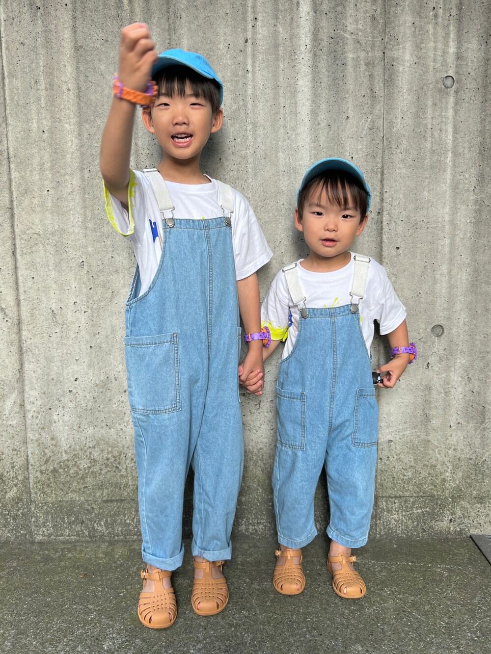 ホワイト系のTシャツ/カットソー、ブルー系のサロペット/オーバーオール、ベージュ系のサンダルを着用したキッズの夏コーディネートの2枚目の写真