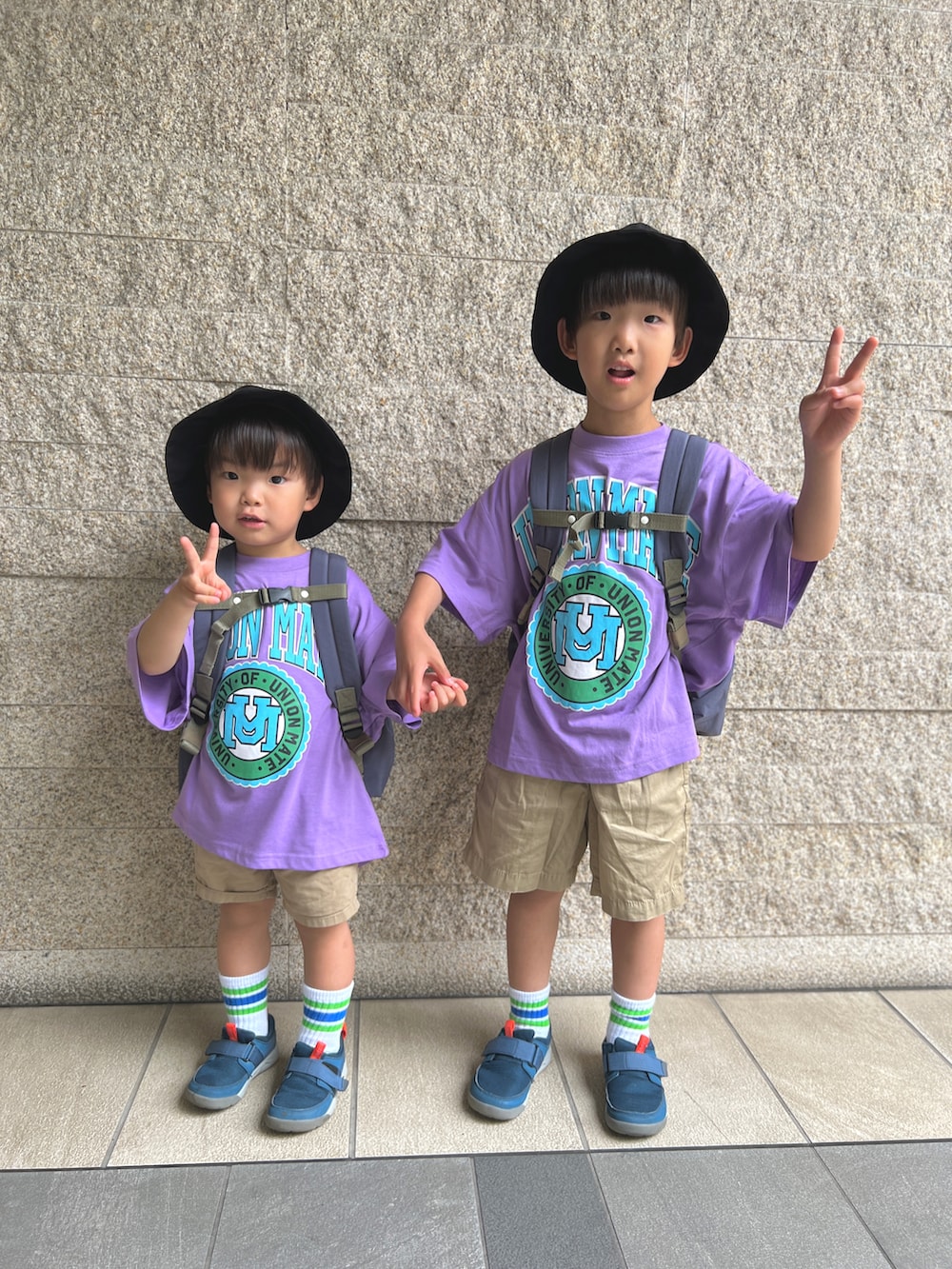 パープル系のTシャツ/カットソー、ベージュ系のパンツ、ブルー系のスニーカーを着用したキッズの夏コーディネートの2枚目の写真