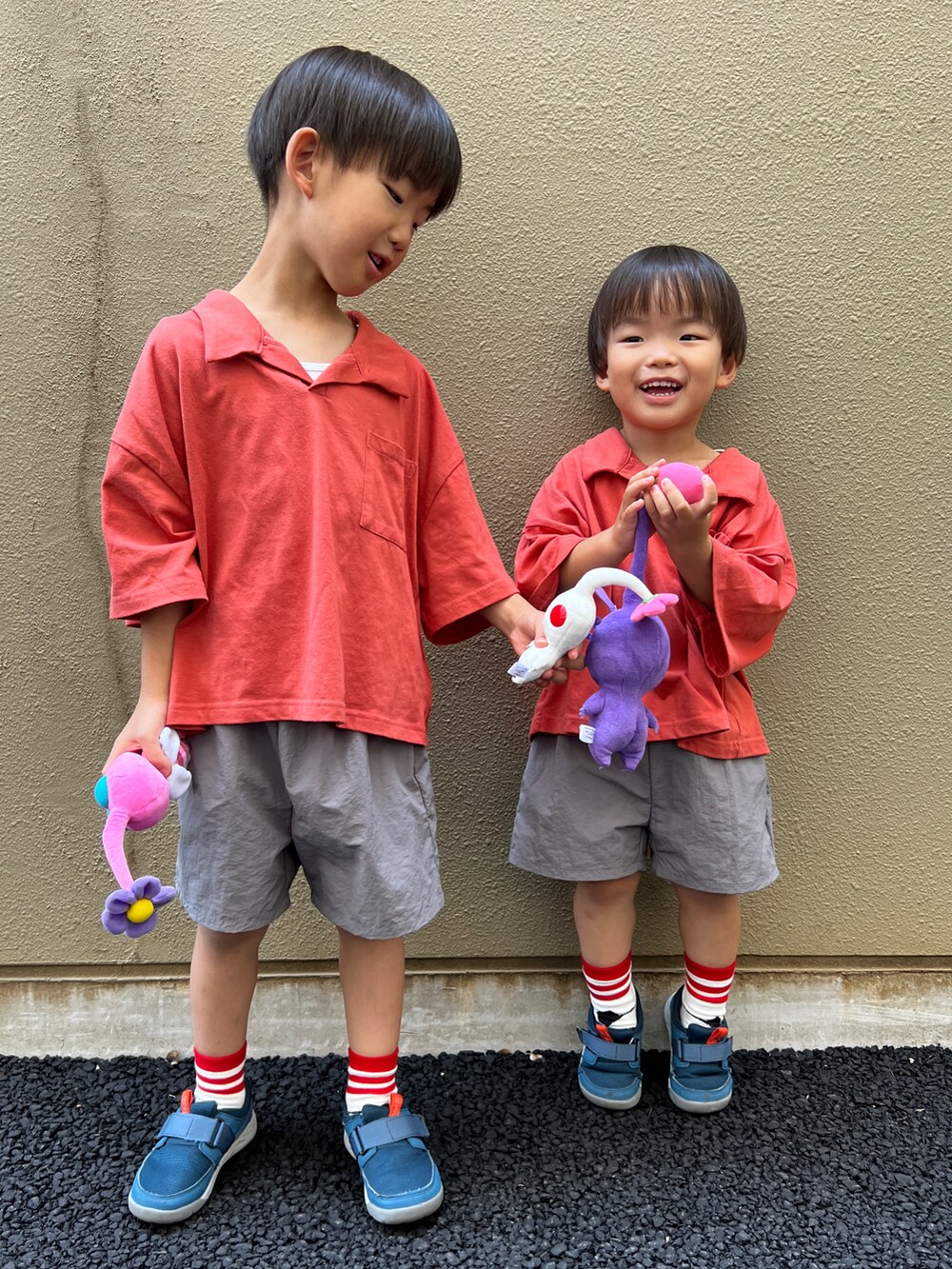 レッド系のセットアップ、ブルー系のスニーカー、ホワイト系のソックス/靴下を着用したキッズの夏コーディネートの3枚目の写真