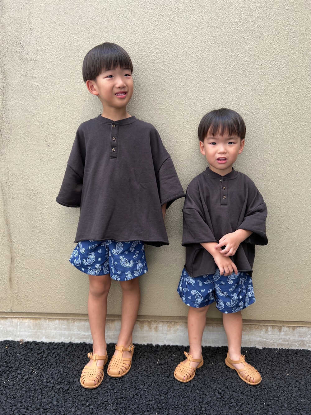 ブラック系のセットアップ、ブルー系のその他パンツ、ベージュ系のサンダルを着用したキッズの夏コーディネートの2枚目の写真