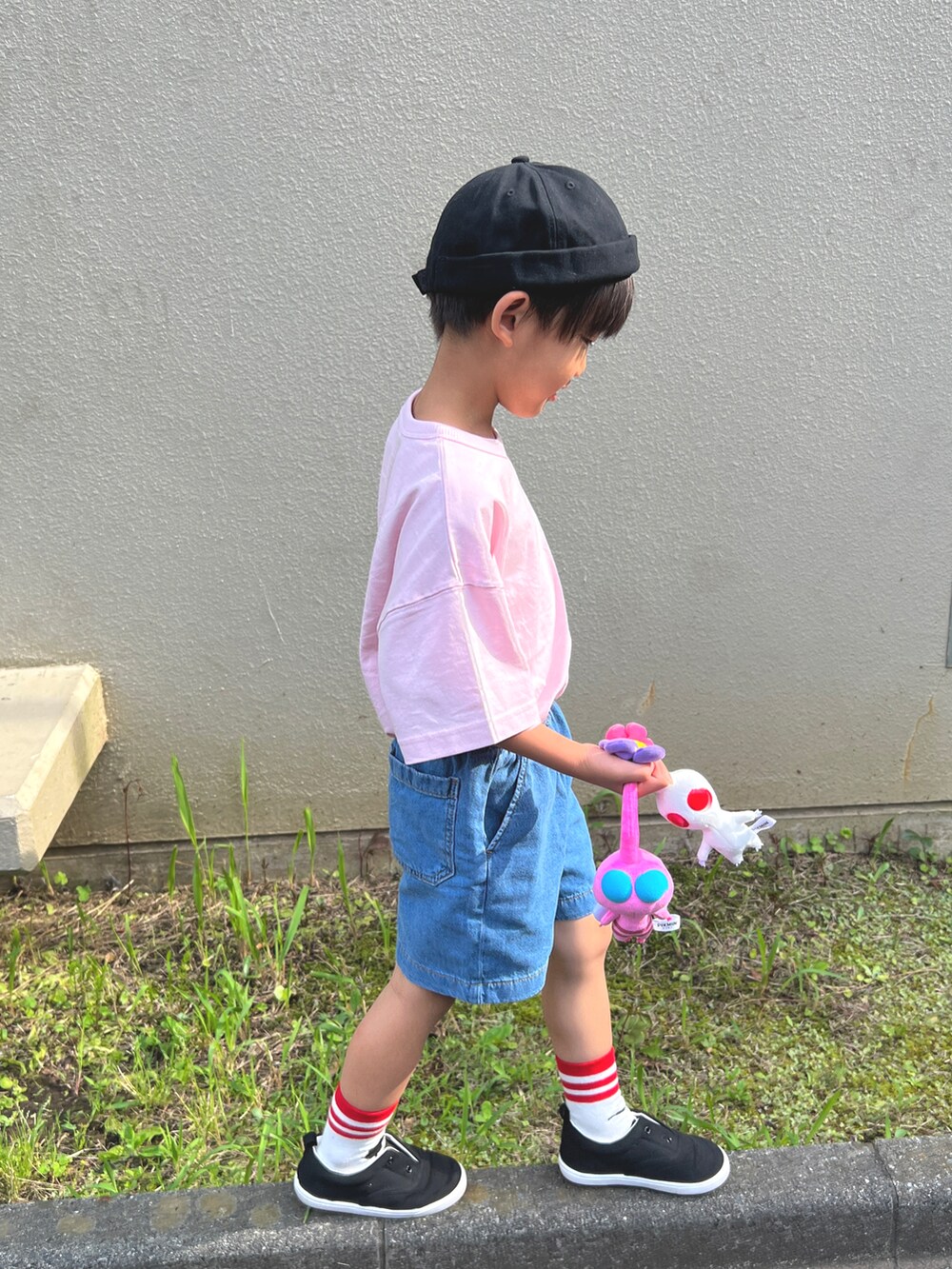 ピンク系のトップス、ブルー系のデニムパンツ、ブラック系のスニーカーを着用したキッズの夏コーディネートの2枚目の写真