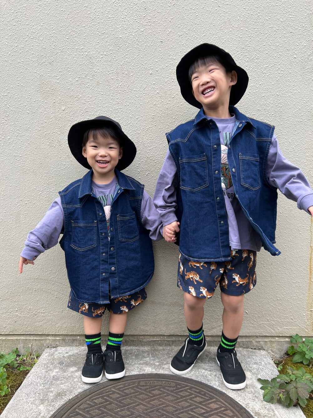 ブルー系のベスト、パープル系のTシャツ/カットソー、ブラック系のスニーカーを着用したキッズの秋コーディネートの2枚目の写真
