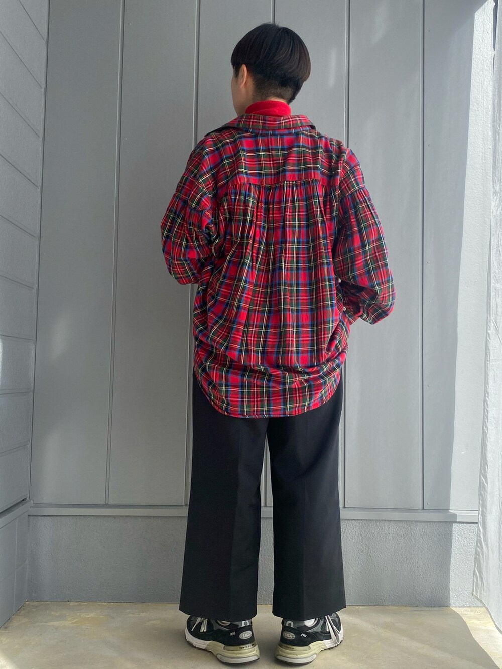 レッド系のニット/セーター、ブラック系のスラックス、レッド系のシャツ/ブラウスを着用したレディースの冬コーディネートの2枚目の写真