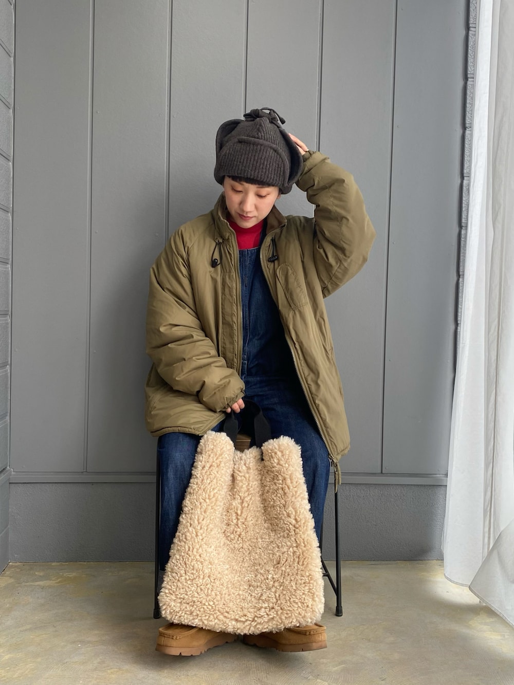 ブルー系のサロペット/オーバーオール、ブラック系のバックパック/リュック、ブラウン系のブーツを着用したレディースの秋コーディネートの3枚目の写真