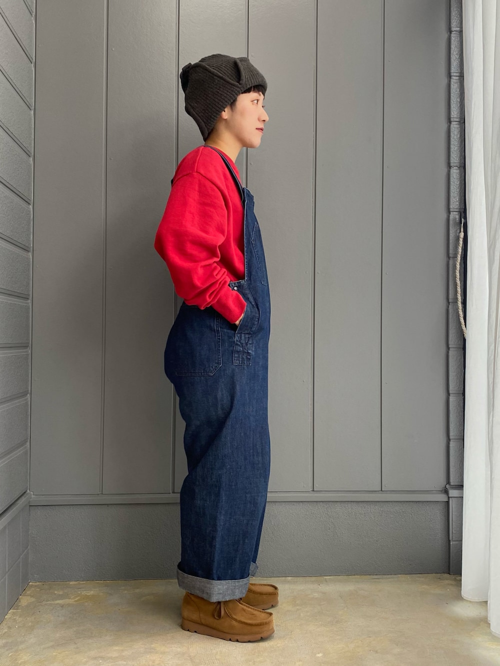 ブルー系のサロペット/オーバーオール、ブラック系のバックパック/リュック、ブラウン系のブーツを着用したレディースの秋コーディネートの5枚目の写真