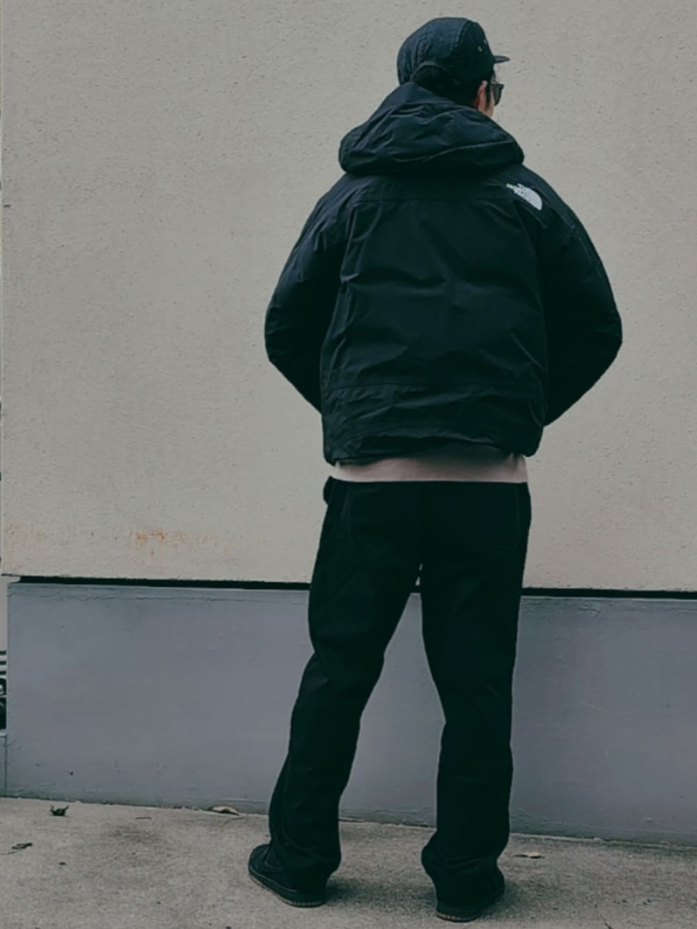 ブラック系のダウンジャケット/コート、グレー系のスウェット、ブラック系のチノパンツを着用したメンズの冬コーディネートの3枚目の写真