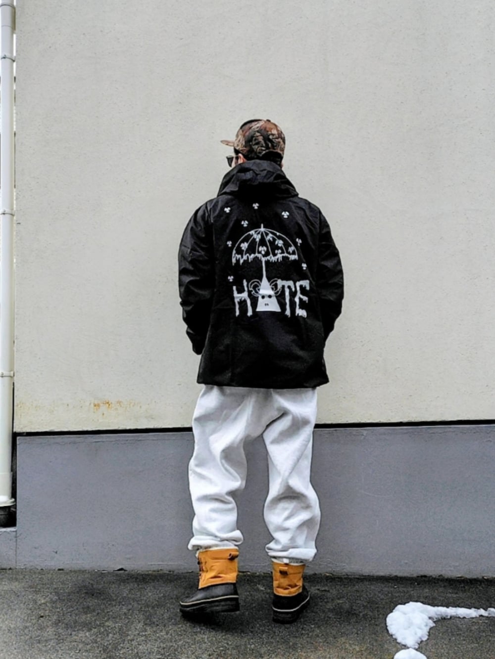 ブラック系のナイロンジャケット、グレー系のスウェットパンツ、ブラウン系のブーツを着用したメンズの冬コーディネートの2枚目の写真