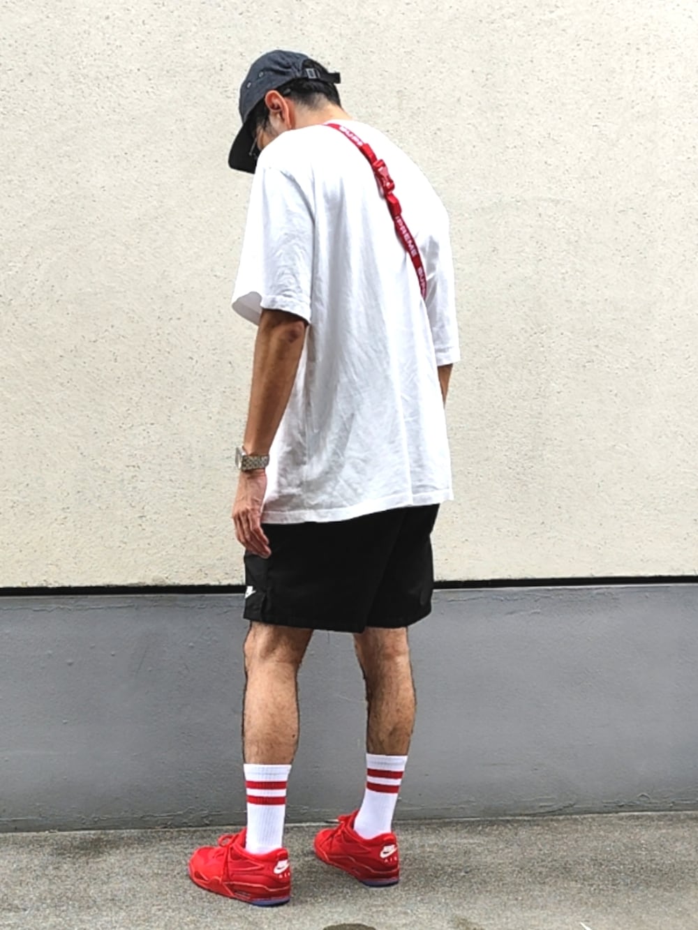 レッド系のボディバッグ/ウエストポーチ、ホワイト系のTシャツ/カットソー、ブラック系のスウェットパンツを着用したメンズの夏コーディネートの2枚目の写真