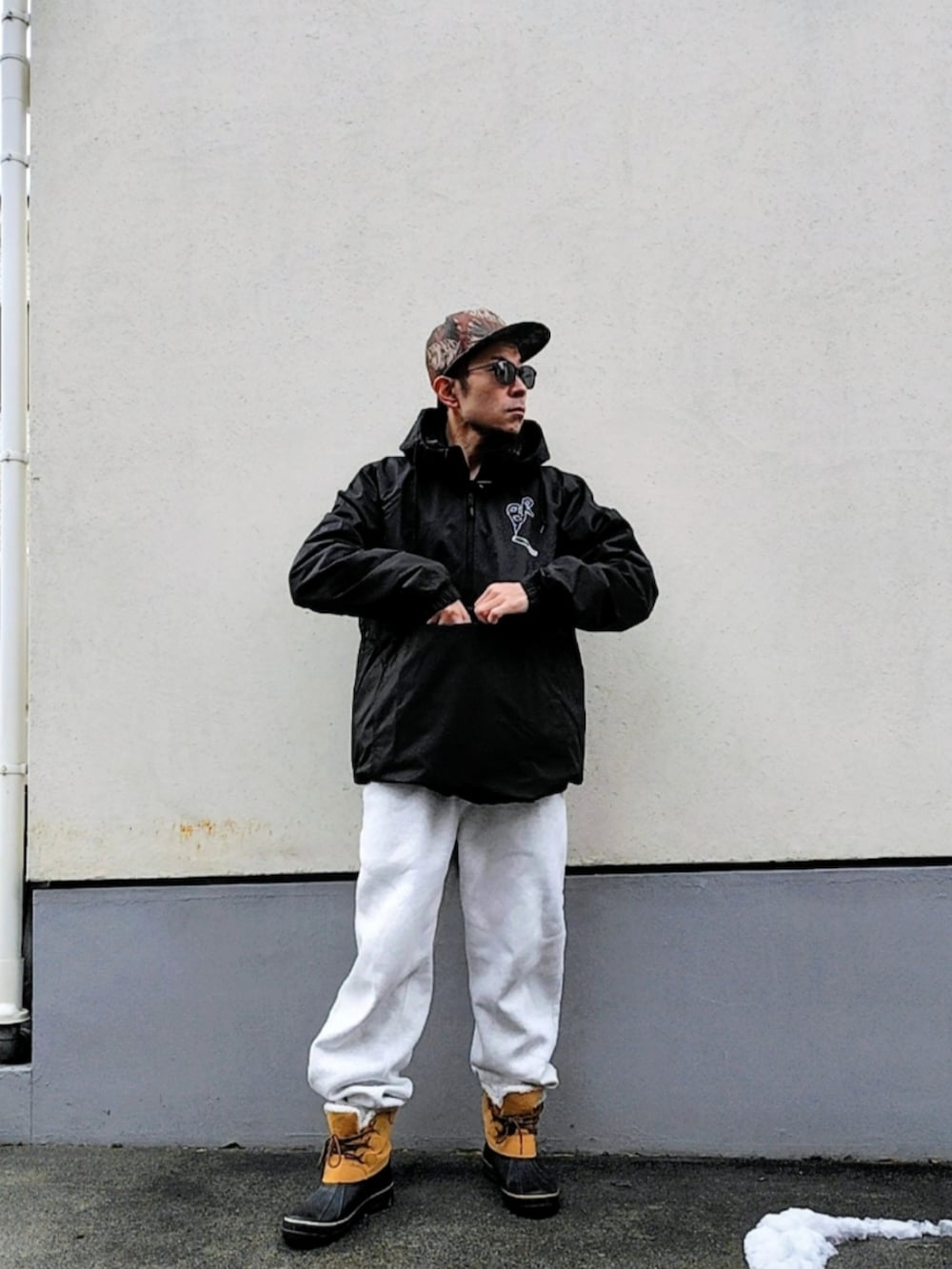 ブラック系のナイロンジャケット、グレー系のスウェットパンツ、ブラウン系のブーツを着用したメンズの冬コーディネートの3枚目の写真