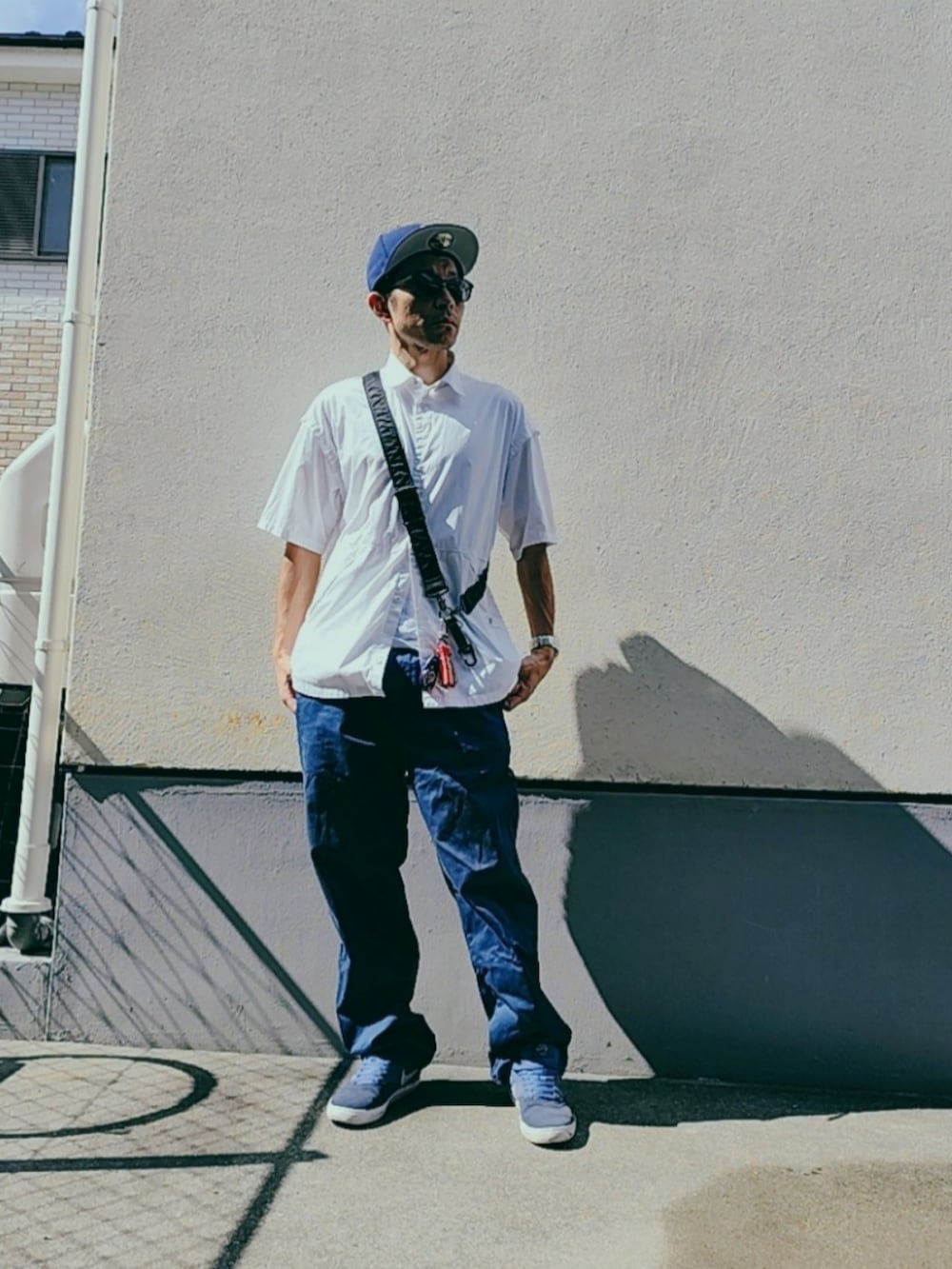 ホワイト系のシャツ/ブラウス、ブルー系のスニーカー、ブルー系のチノパンツを着用したメンズの秋コーディネートの2枚目の写真