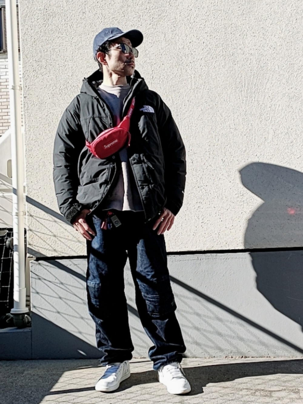 グレー系のスウェット、レッド系のボディバッグ/ウエストポーチ、ブラック系のダウンジャケット/コートを着用したメンズの冬コーディネートの3枚目の写真